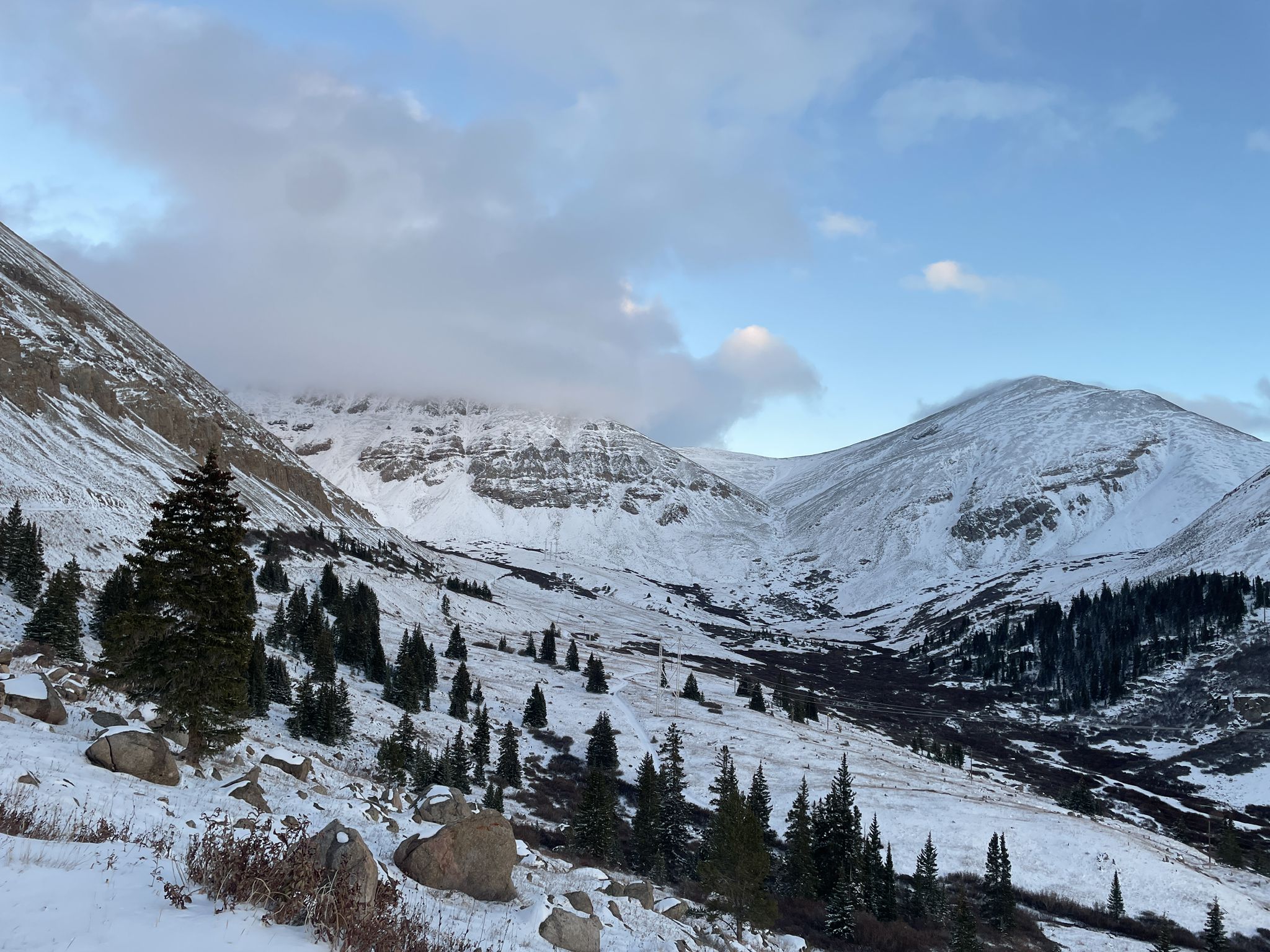 Snow-covered mountains and valley with evergreen trees under a cloudy sky. - Mineral Belt Trail – Leadville mines loop from Leadville