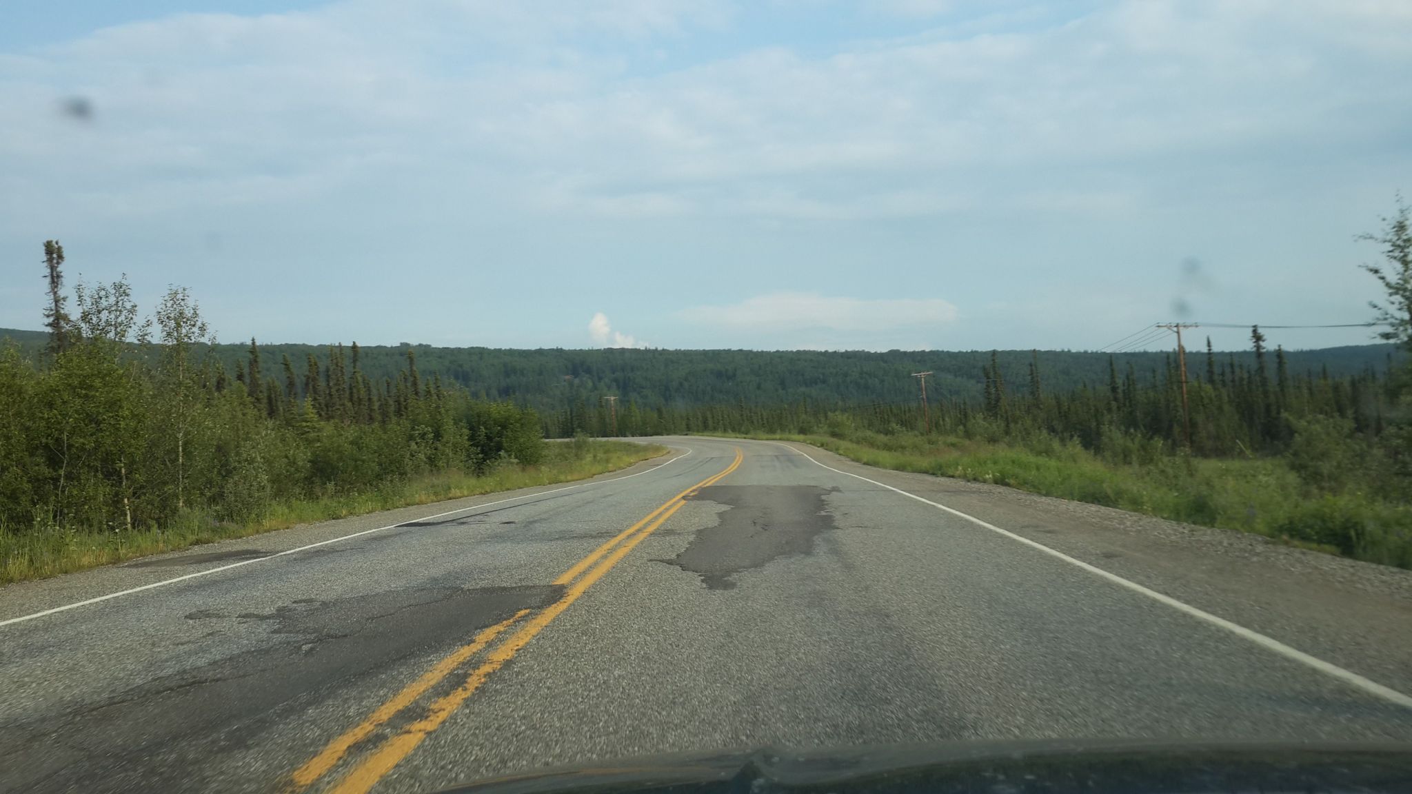 Winding paved road through a green forest under a cloudy sky. - Sheep Creek to Ballaine  Road loop