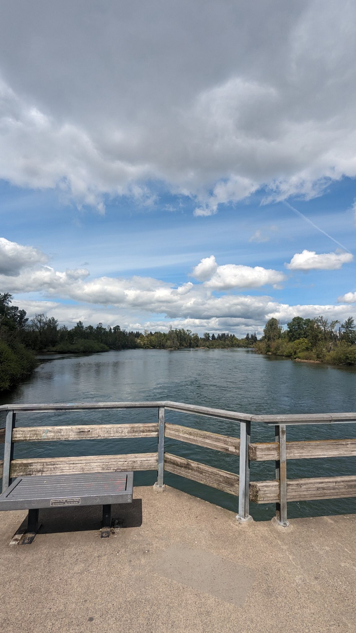 View of a wide river from a bridge with a bench under a cloudy sky. - Alton Baker Park to Greenway Bike Bridge loop