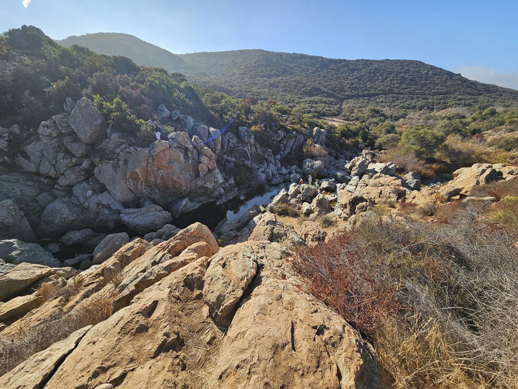 A rugged, rocky canyon with a stream flowing through it on a sunny day. - Los Peñasquitos Falls – Los Peñasquitos Falls loop from Intuit Inc.