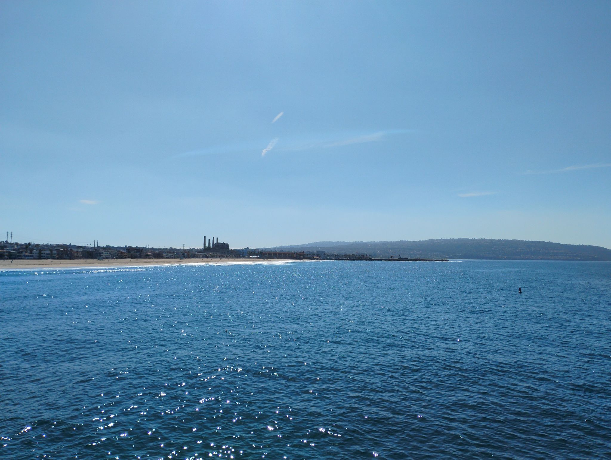 Expansive blue ocean with a distant coastline and hills under a clear sky. - Noble Park – Manhattan Beach and Pier loop from Manhattan Beach