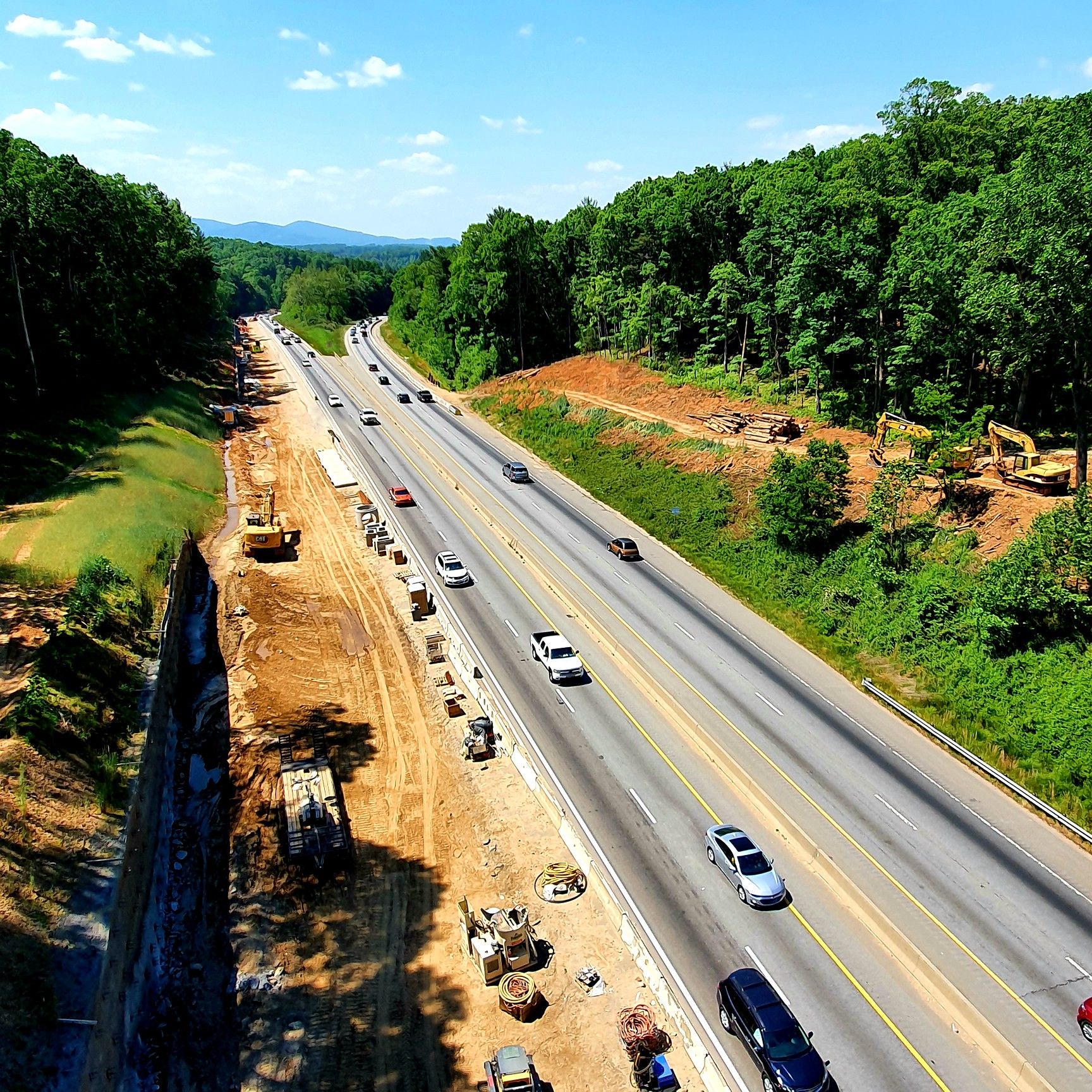 Busy highway with construction on one side, surrounded by green hills. - Mountains-to-Sea Trail