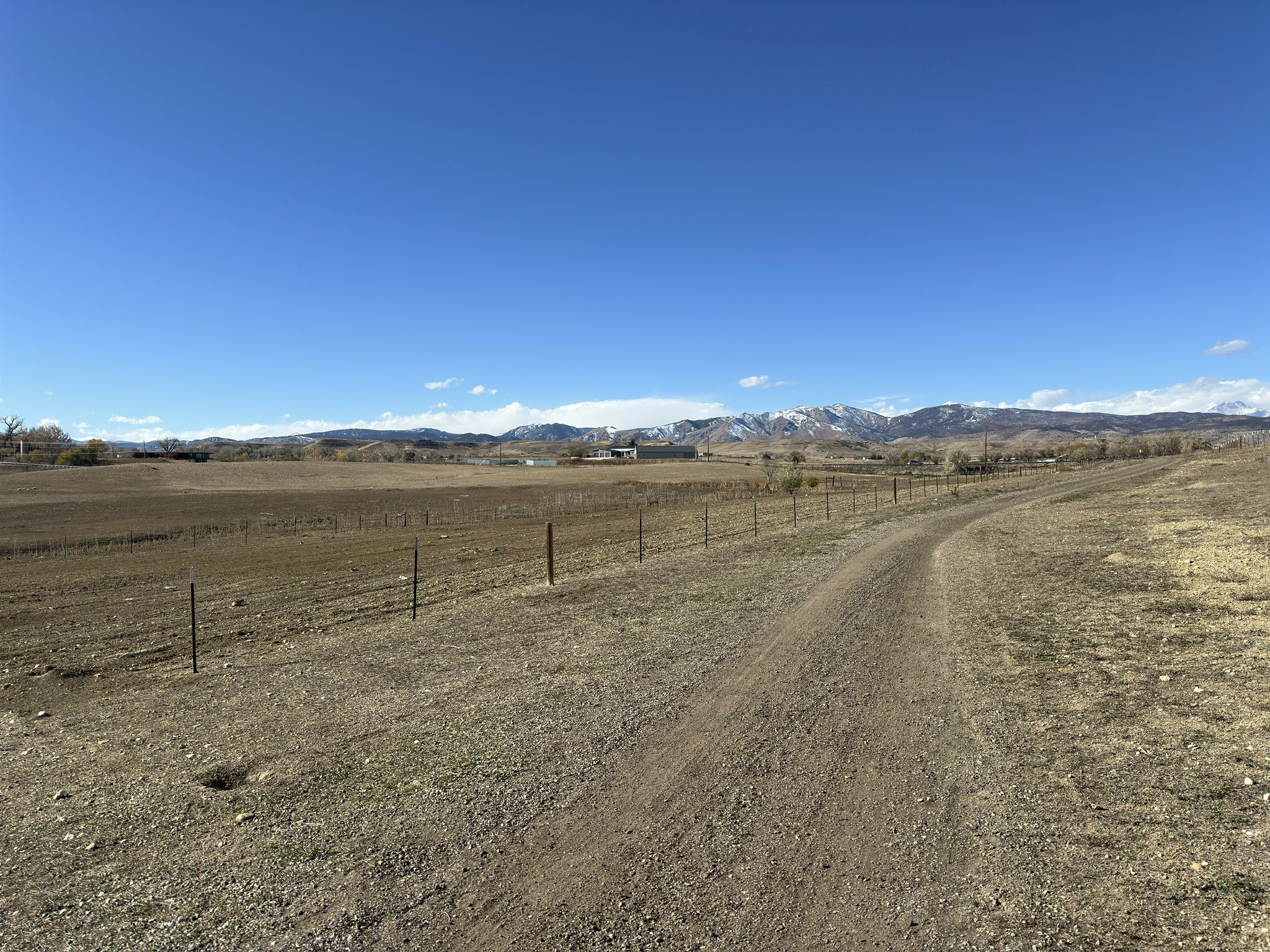 Dirt path through dry fields, snow-capped mountains under a bright blue sky. - Open Sky Loop – Lagerman Preserve Trailhead loop from Seagate Technology