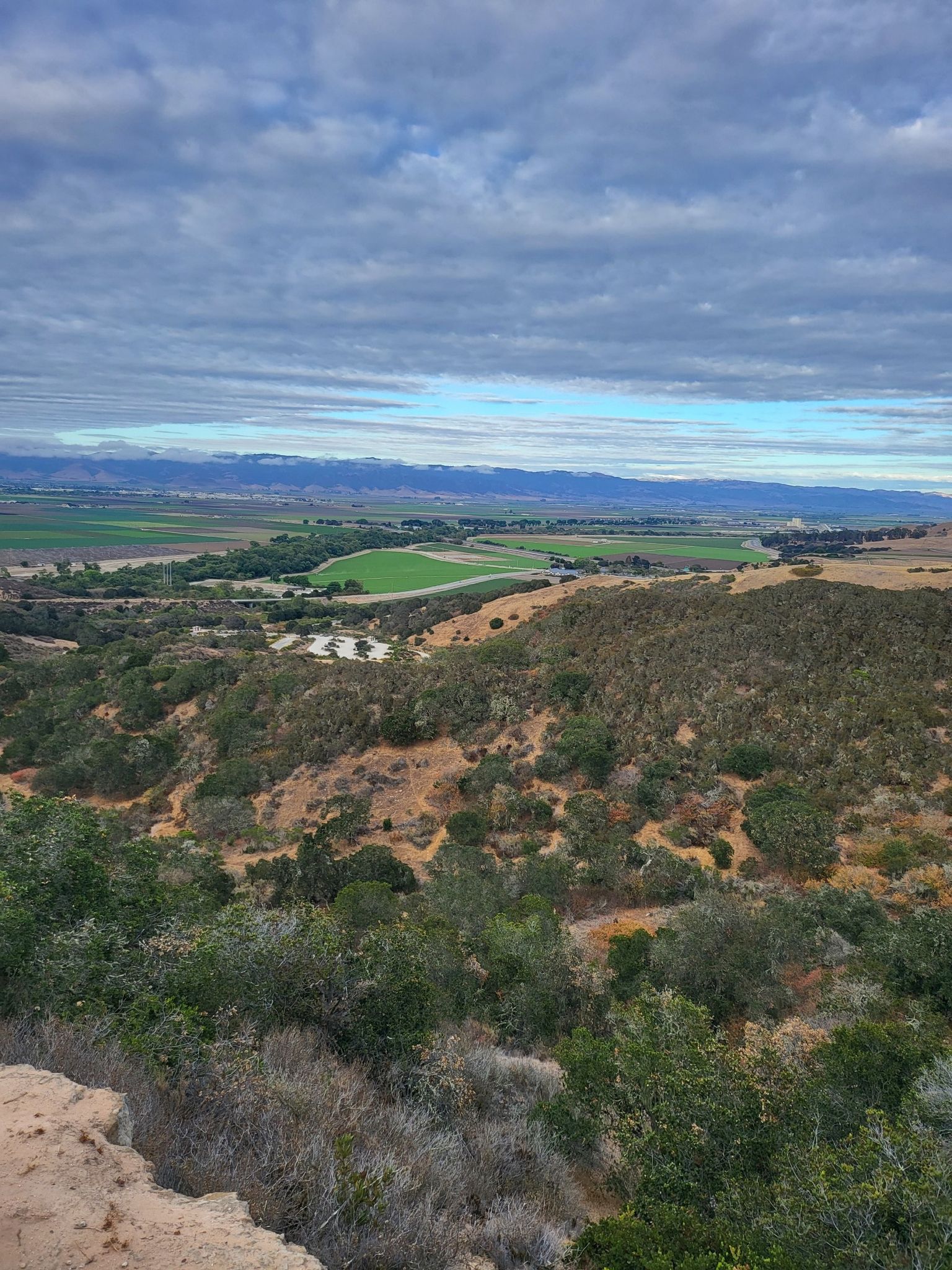 Expansive view of rolling hills, green fields, and distant mountains under a cloudy sky. - Trail 41 and Trail 36 Loop