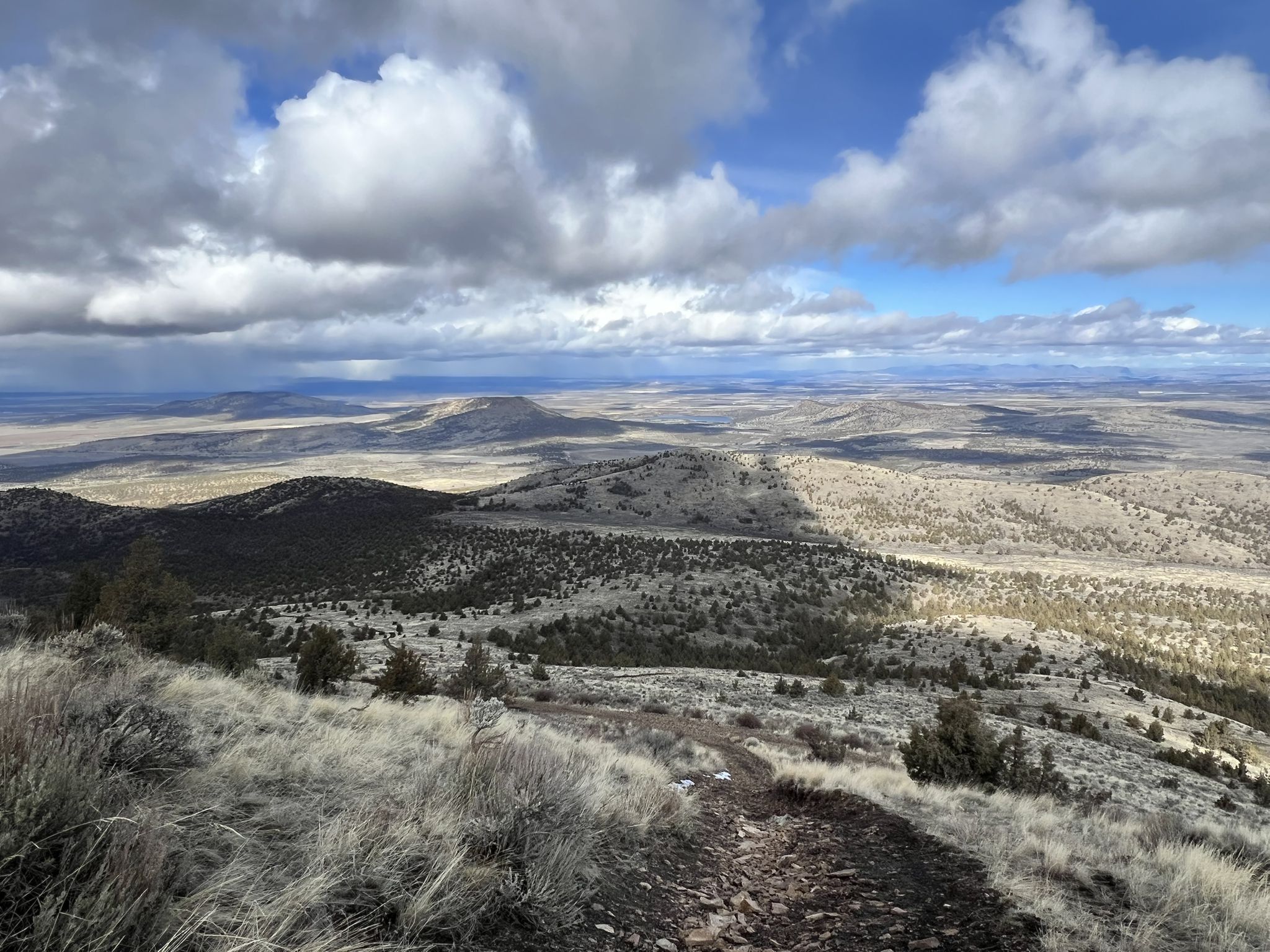 Wide view of arid hills under a partly cloudy sky with shadows. - Cole Loop and Gray Butte Trail