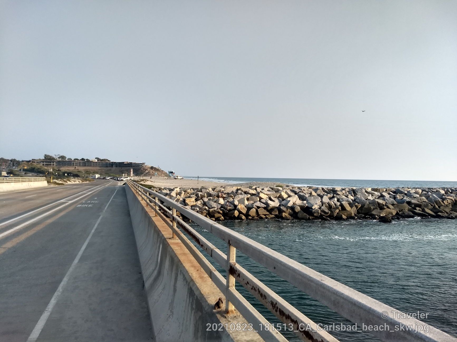 Bridge over water next to a rocky jetty, leading to a distant beach. - West San Marcos loop