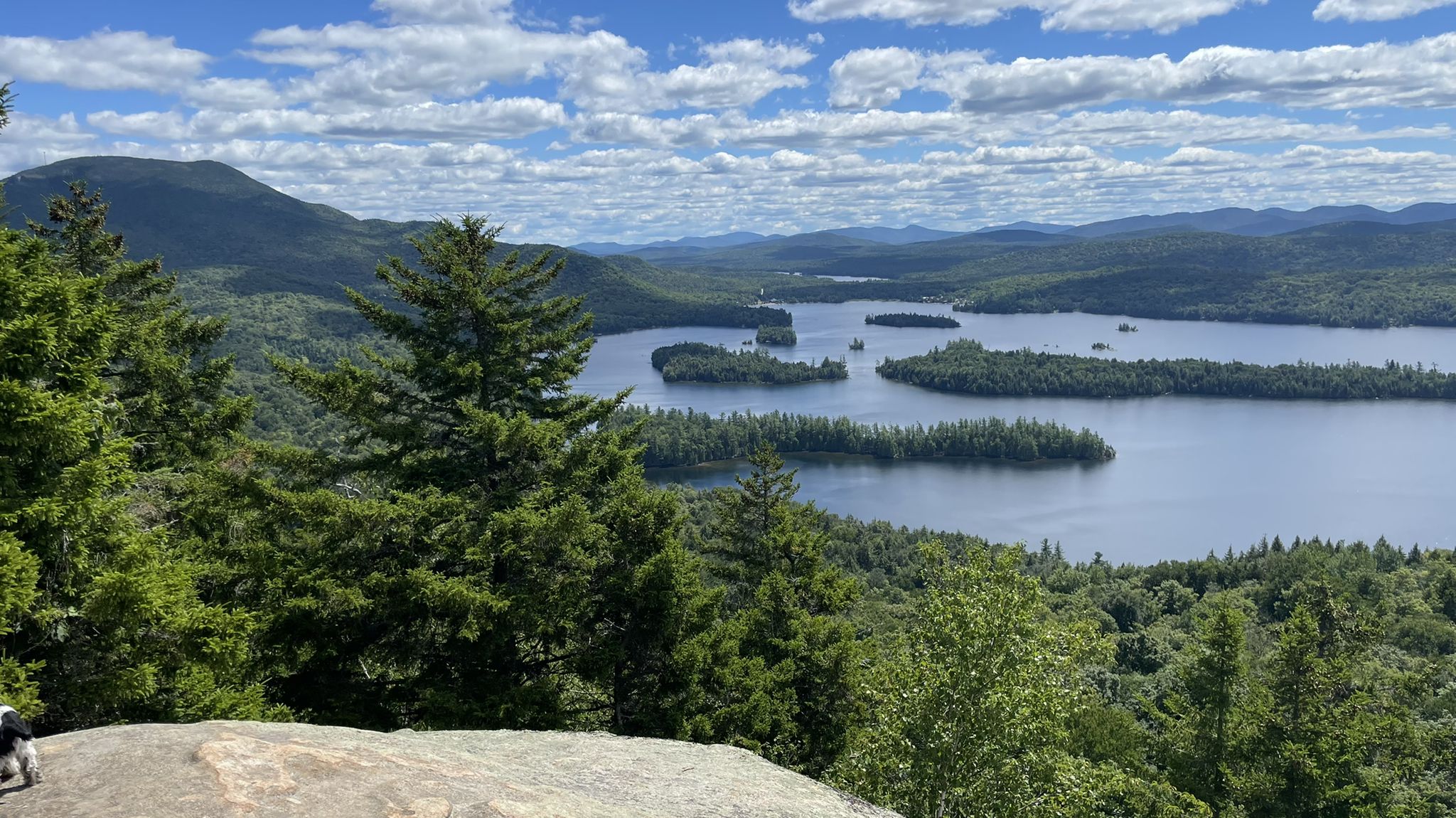 Sunny mountain vista overlooking a large lake dotted with forested islands. - Castle Rock and Chub Pond Loop