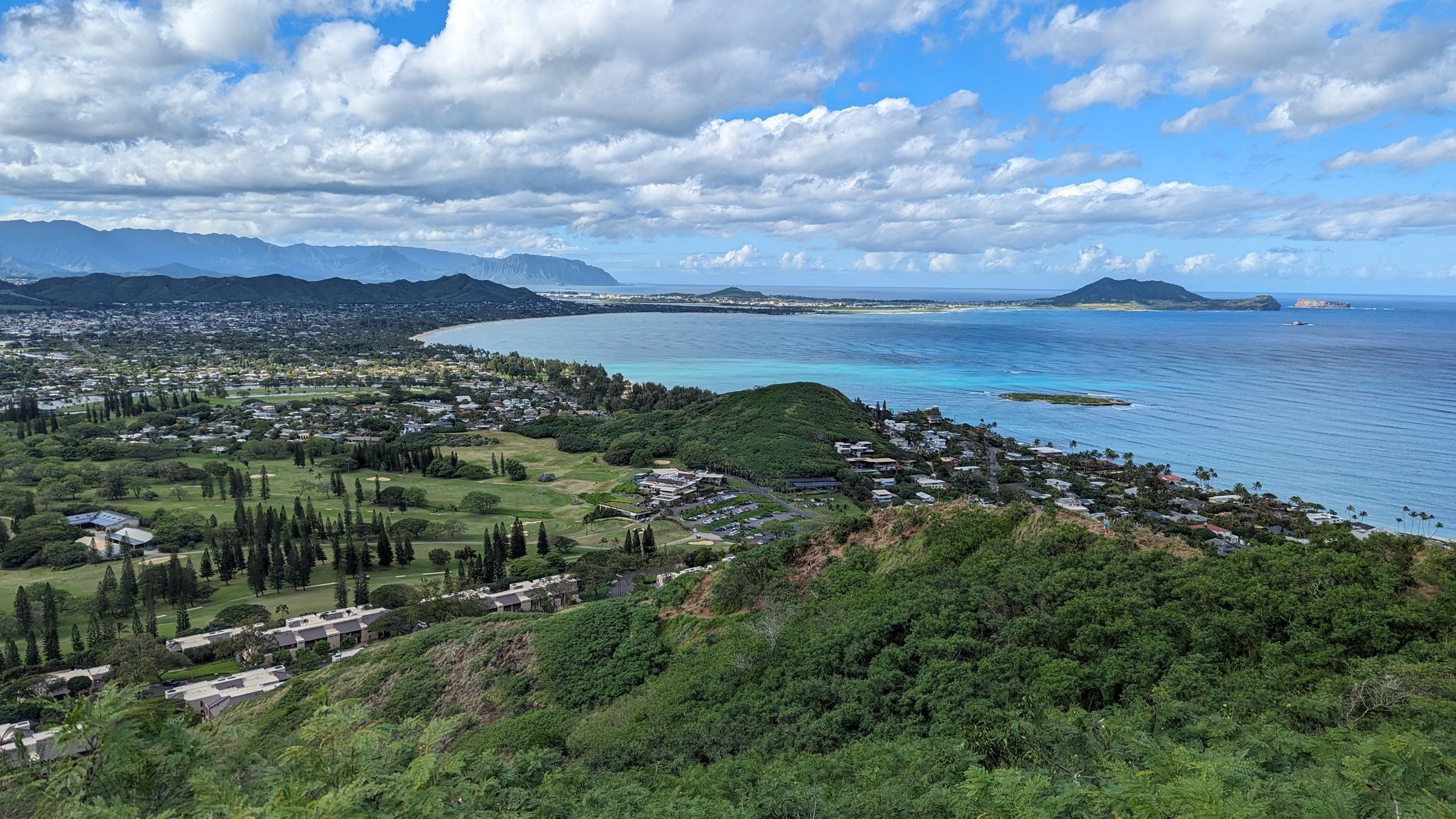 Aerial view of a coastal town, green landscape, and turquoise ocean with islands. - Lanikai Pillbox No. 2 Viewpoint – Lanikai Pillbox 1 loop from Keolu Drive + Iana Street