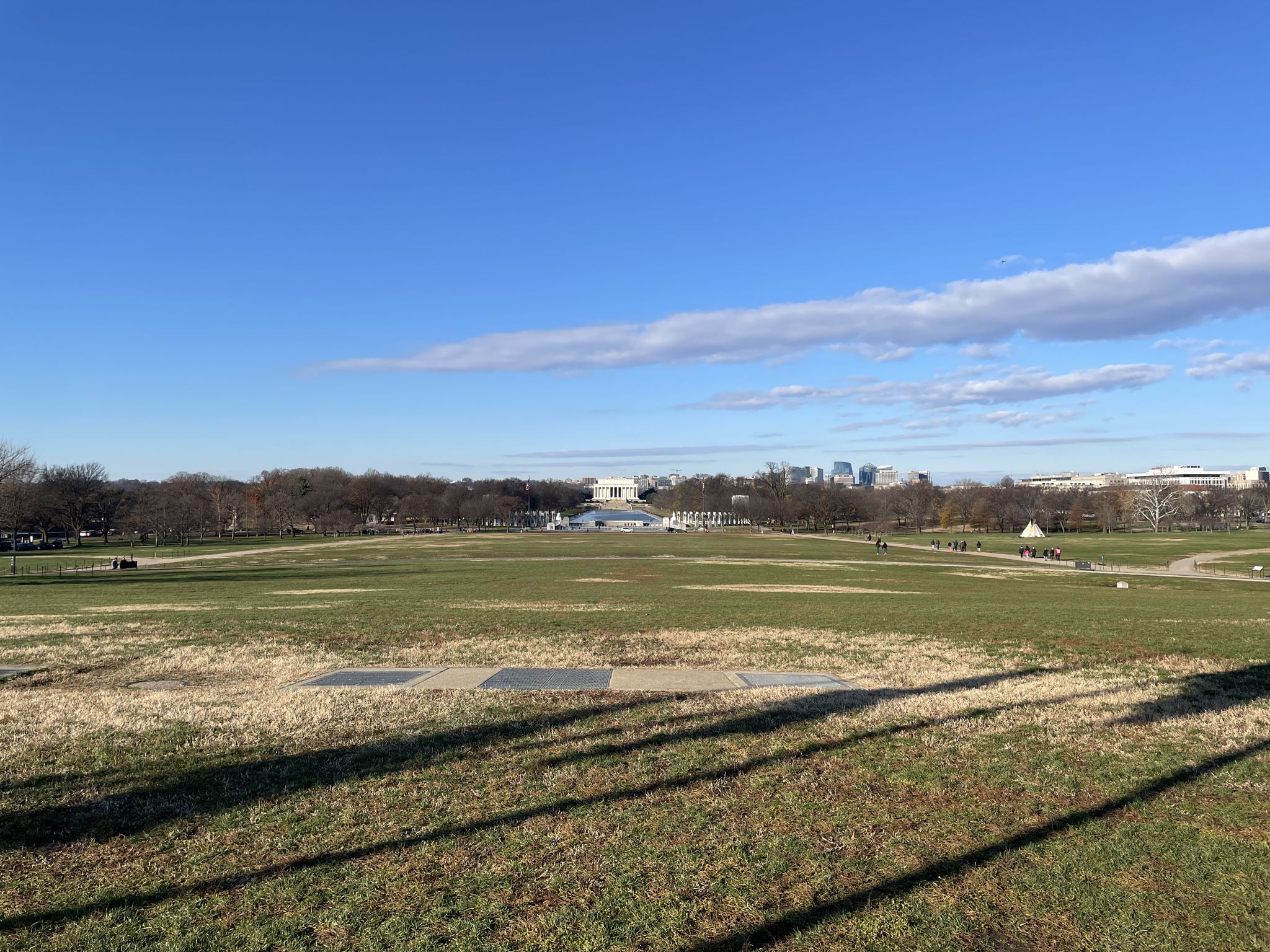 Wide grassy field under clear blue sky, distant white building. - U.S. Capitol – Lincoln Memorial loop from Stadium–Armory