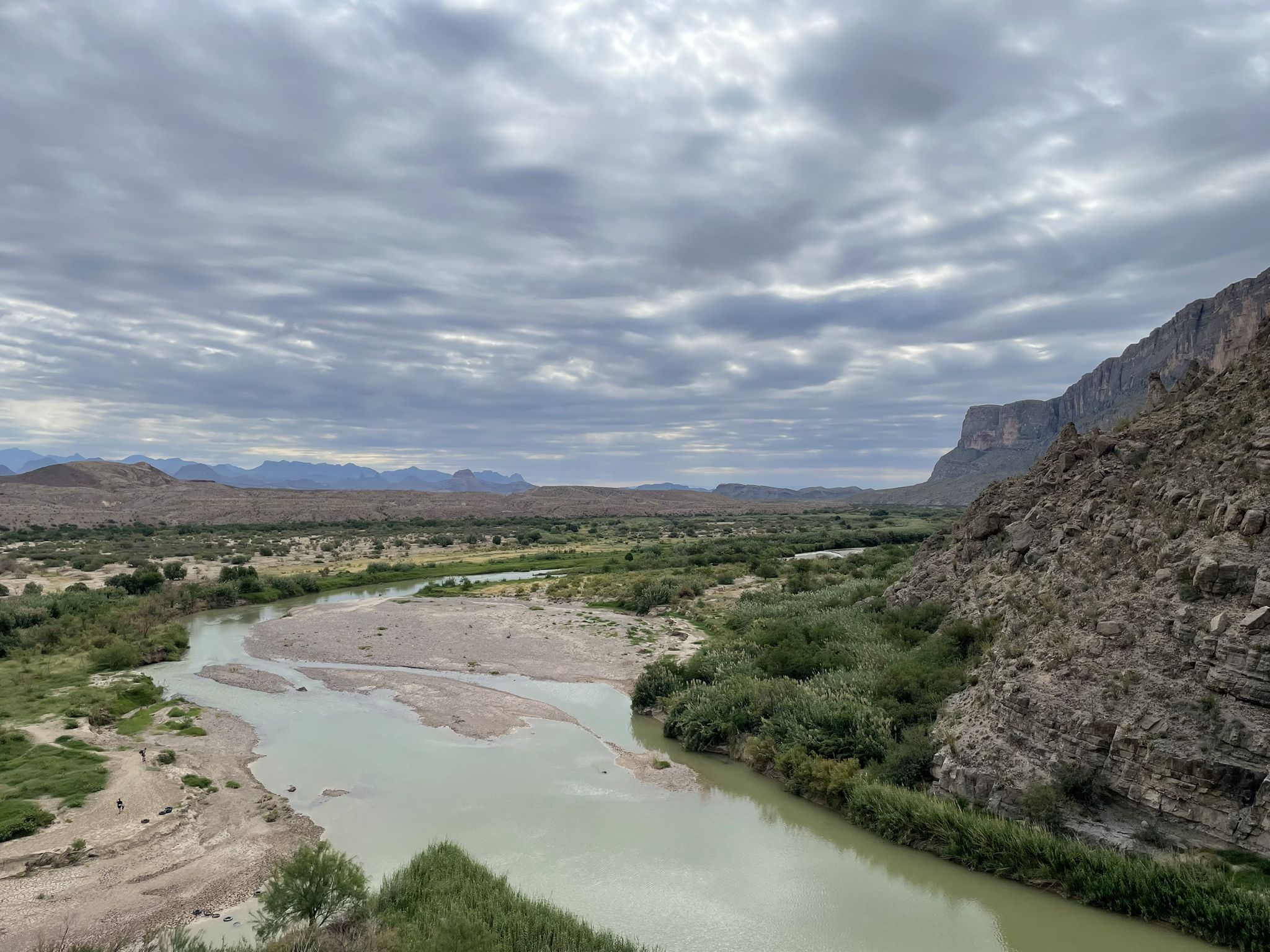 River winding through a desert landscape under cloudy skies. - Santa Elena Canyon Trail