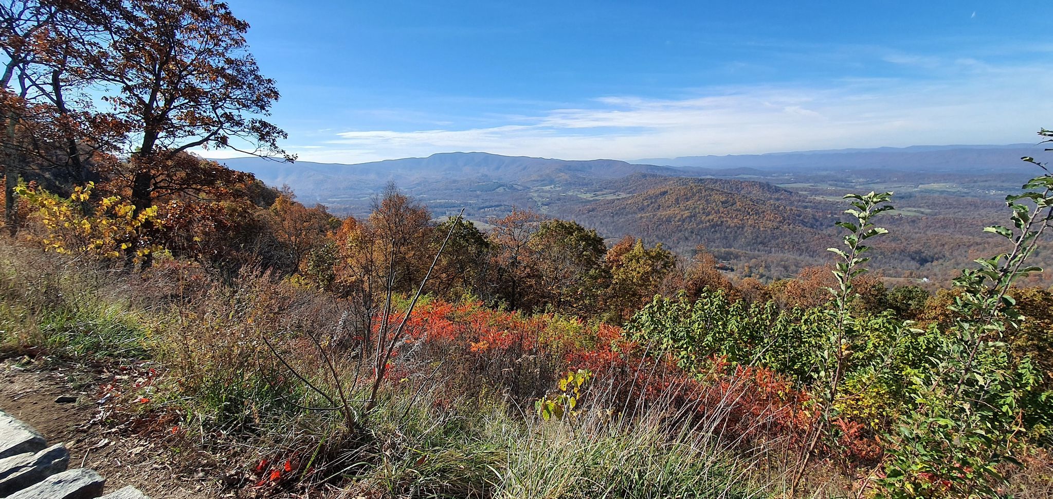 Autumn mountain vista with colorful foliage and distant hazy mountains under blue sky. - Skyline Drive: Front Royal to Waynesboro