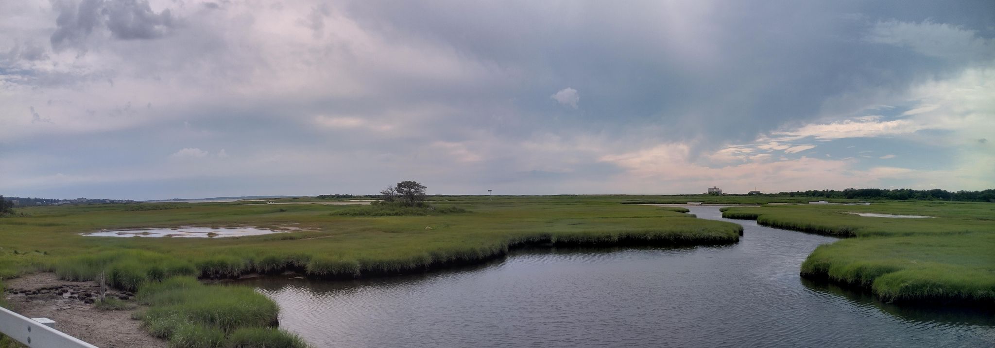 Expansive marshland with winding river under an overcast sky. - Great Sippewissett Marsh – Sagamore Bridge loop from Falmouth