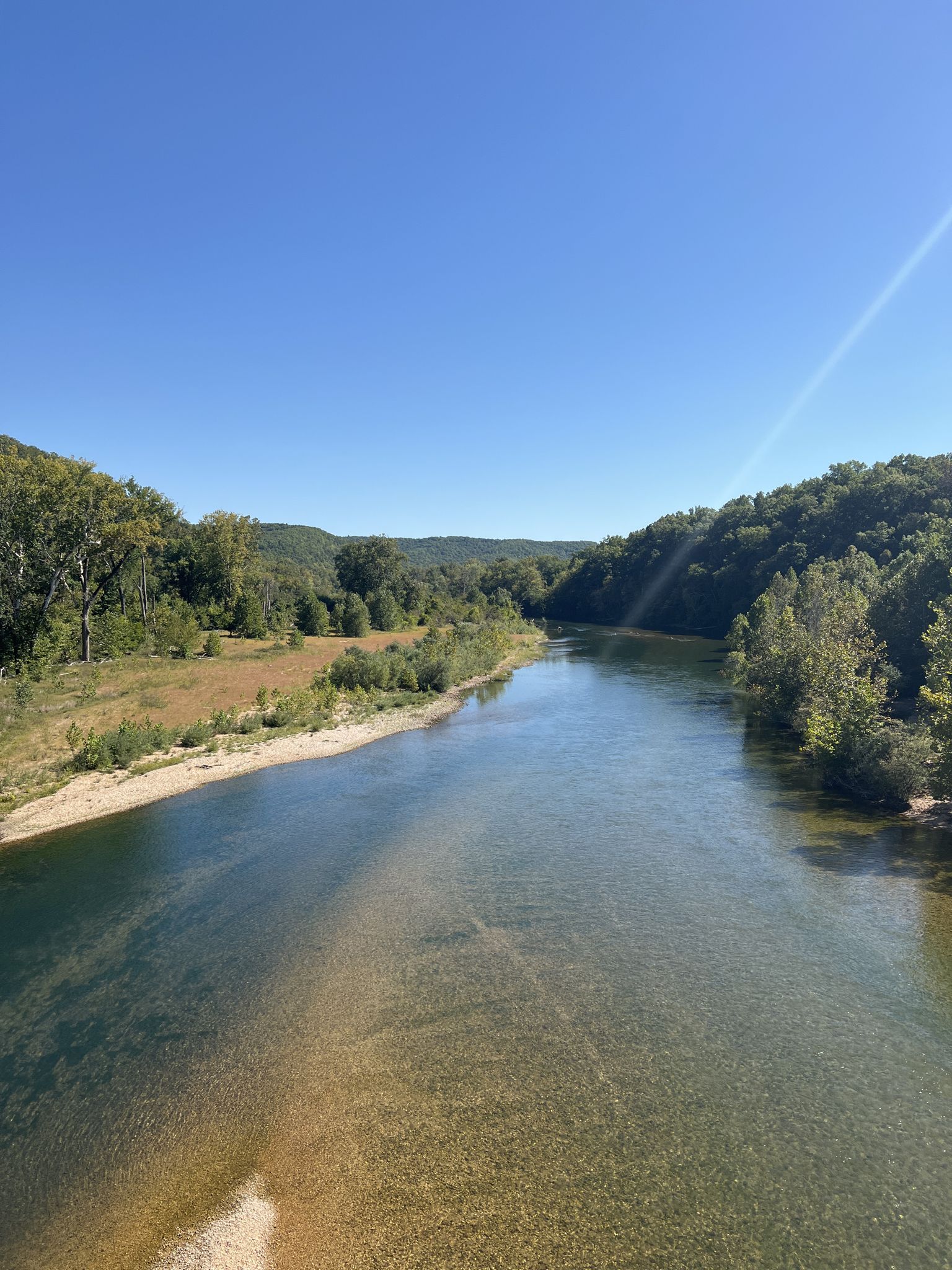 Clear river winding through a green valley under a bright blue sky. - Powder Mills  to Rocky Falls