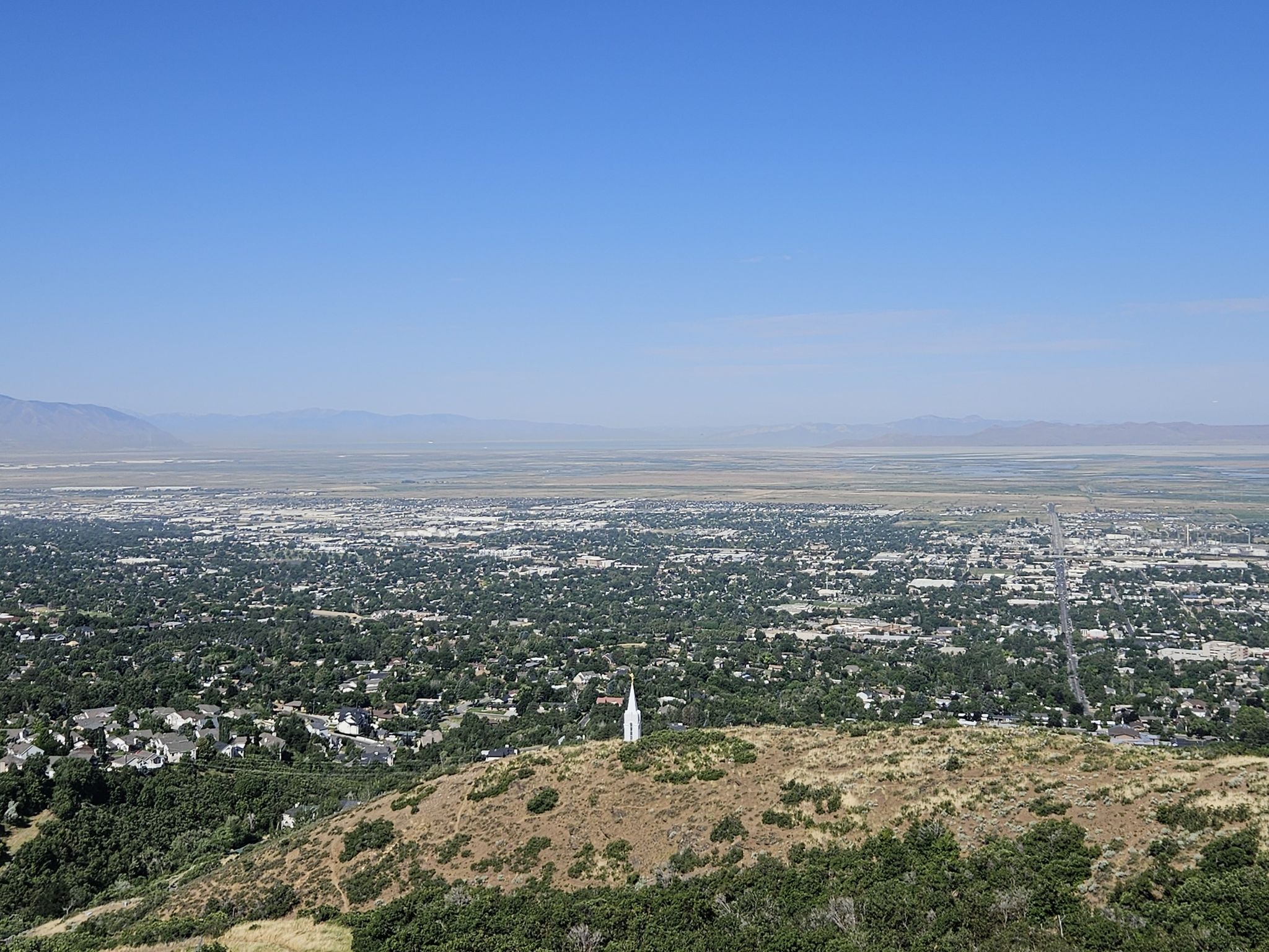 City and valley panorama with a white spire on a dry, brushy hill. - Temple Loop