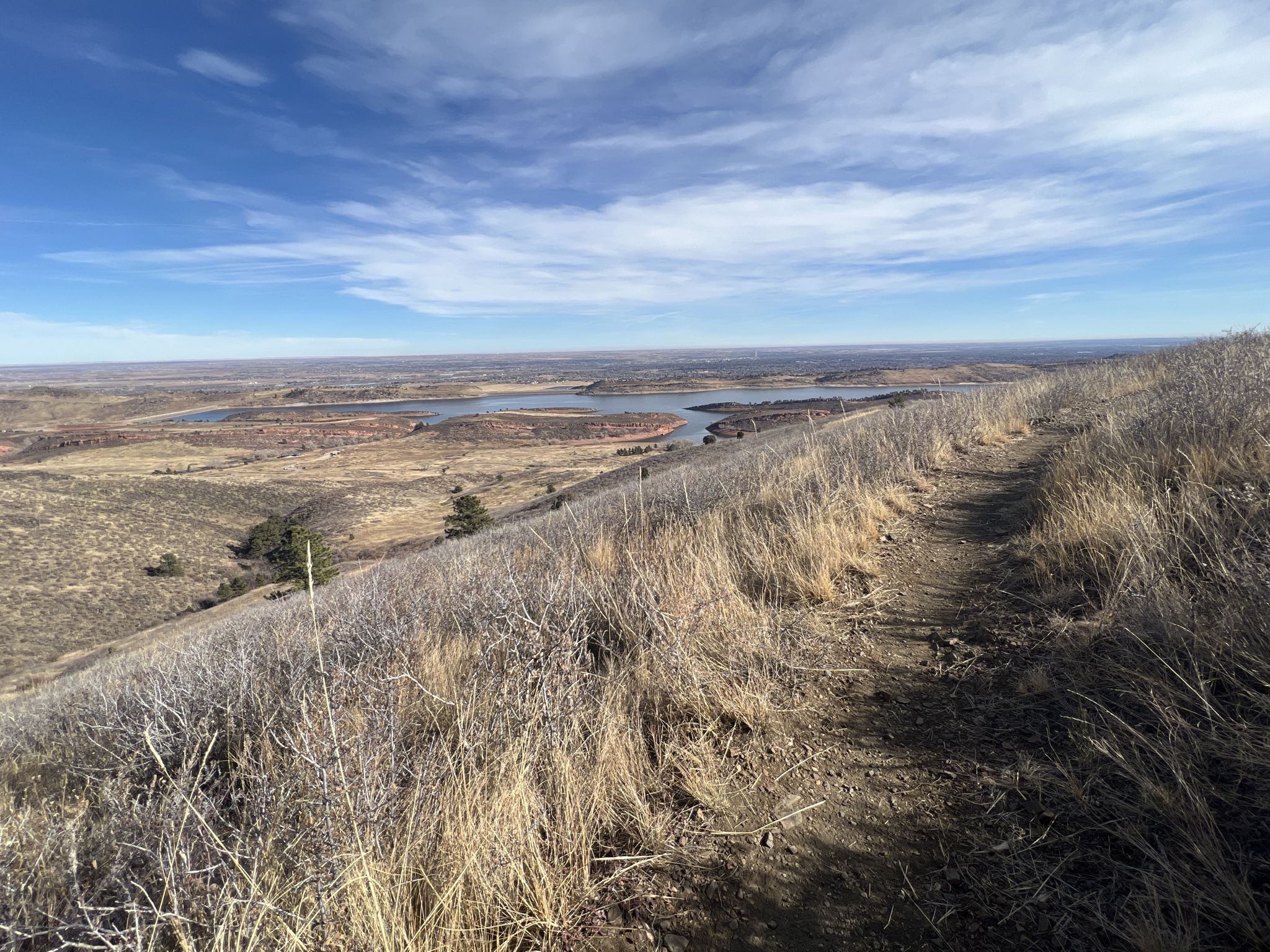Dirt path winding up a dry grassy hill with a distant lake under a blue sky. - Timber, Kimmons, and West Valley Trail Loop