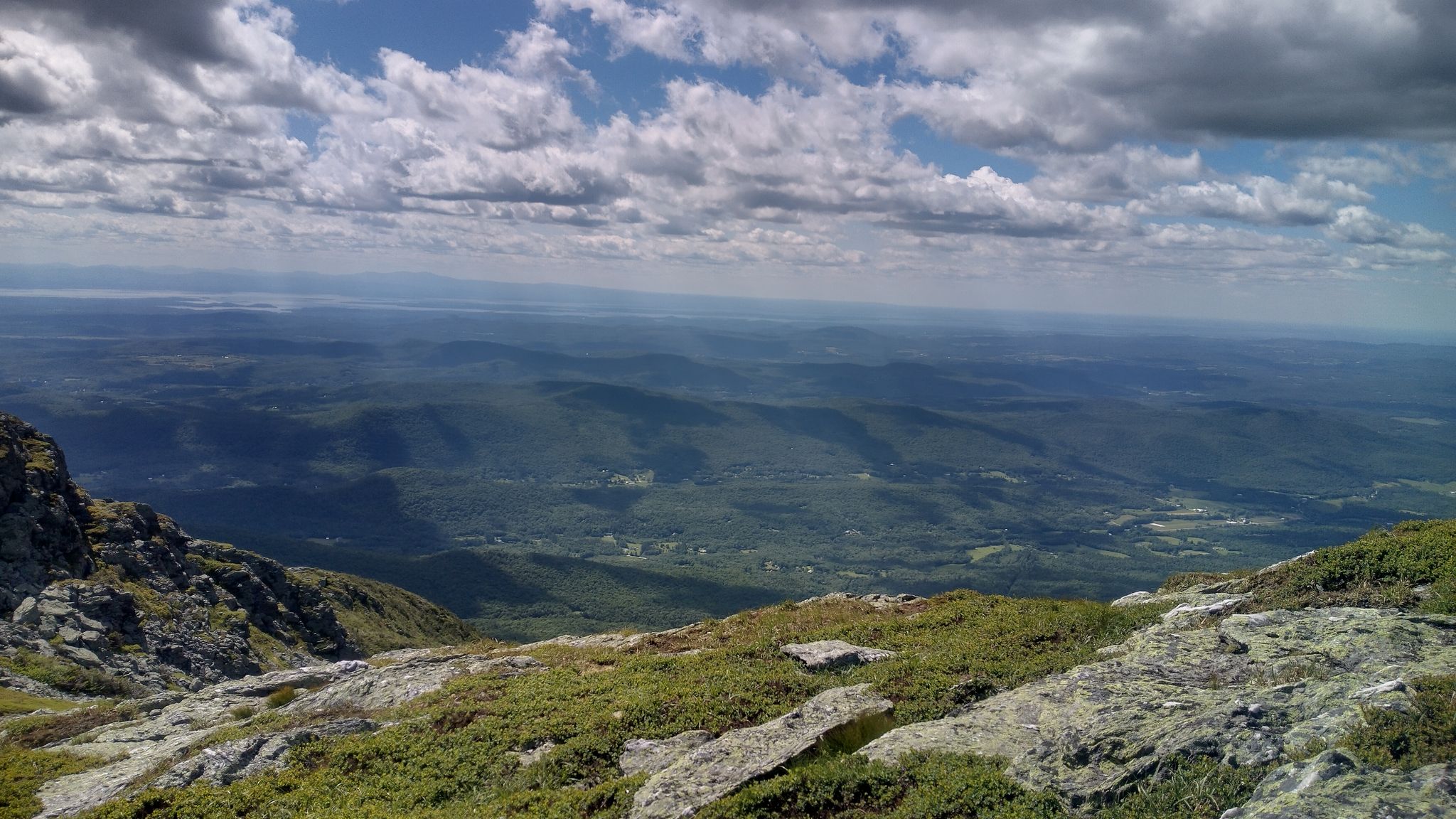 Panoramic mountain view from a rocky outcrop overlooking a green valley. - Mount Mansfield via Long and Profanity Trail