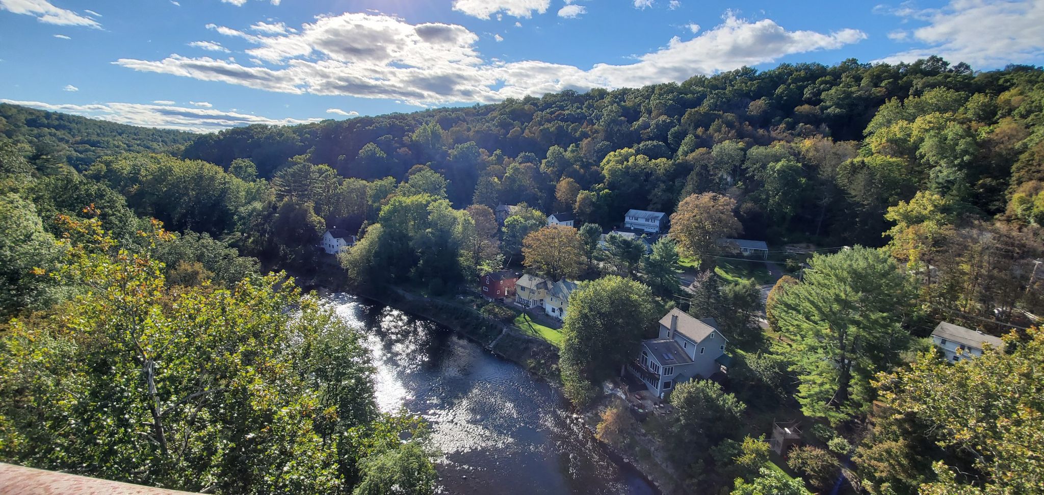Sunny view of a river winding through a green valley with houses. - Rosendale Trestle Bridge – Nice old railway bridge with a view loop from Rosendale
