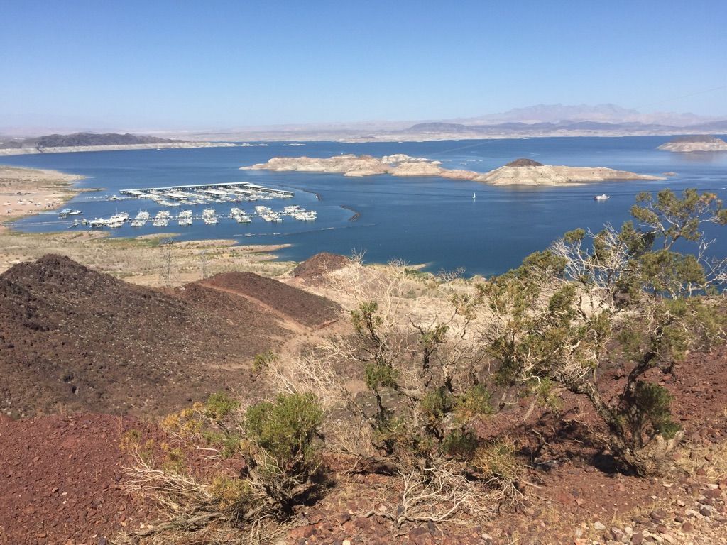 Panoramic view of a vast lake with a marina, surrounded by arid, rocky hills. - Railroad Tunnel Trail