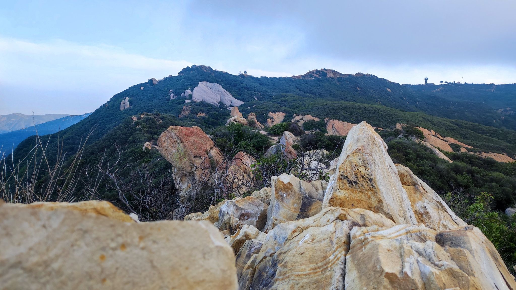 Rugged mountain peaks with green trees under an overcast sky. - Red Rock Canyon and Topanga Lookout Loop