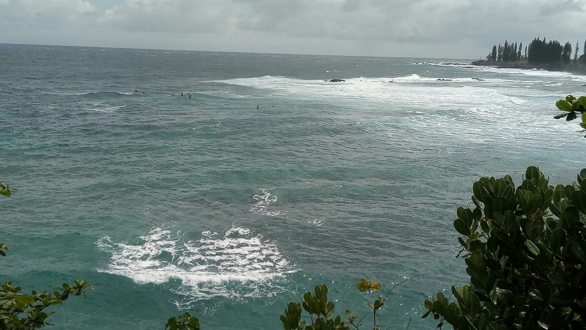 Overcast view of blue-green ocean with breaking waves and distant coastline. - Hāmoa Beach loop from Mokae