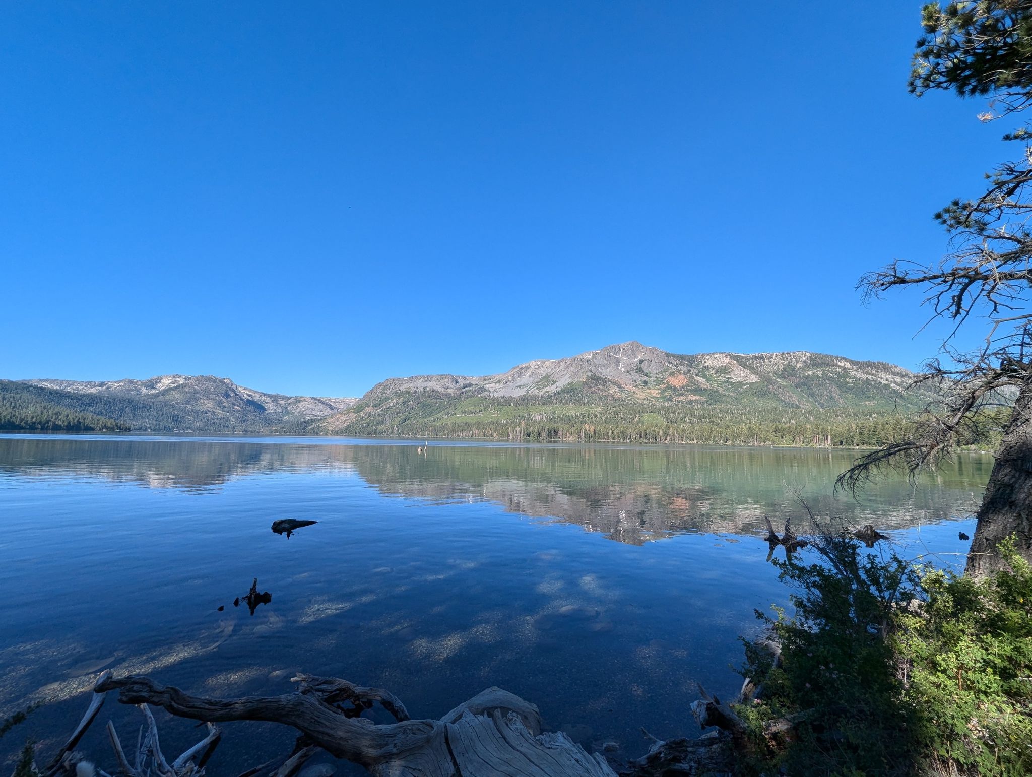 Clear blue lake reflecting mountains under a bright, clear sky. - Tahoe Mountain and Angora Ridge Loop