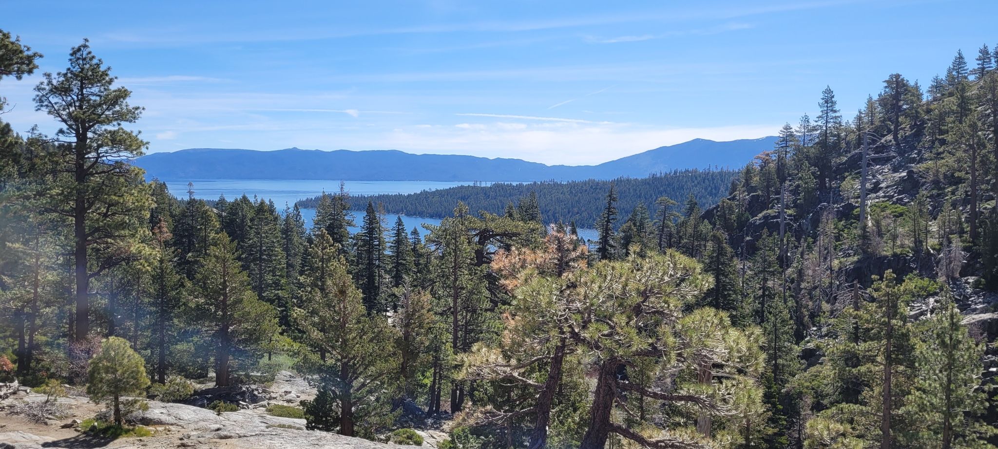 Panoramic view of a large lake surrounded by pine forests and mountains. - Eagle Trail Loop