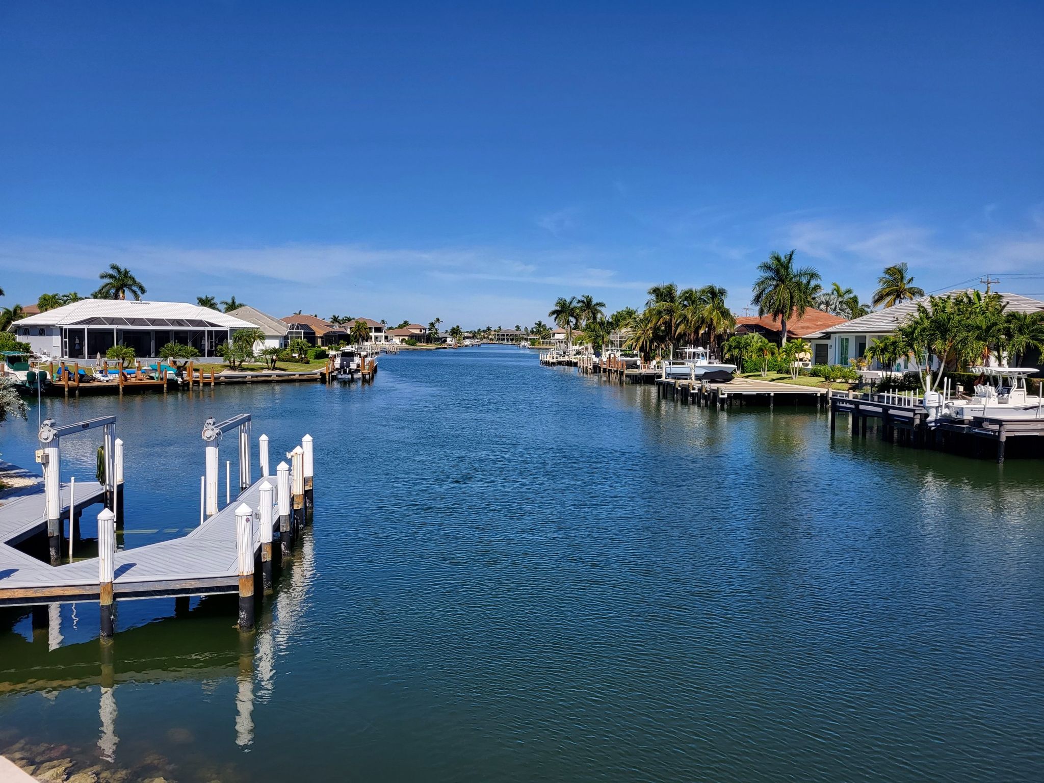 Sunny canal with boats, docks, and houses under a clear blue sky. - Mackle Park loop from Marco Island
