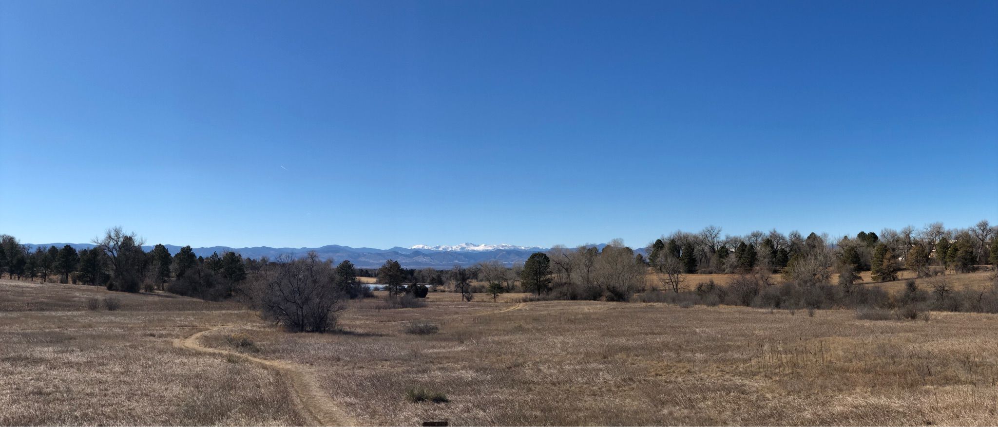 Panoramic view of a dry field with a path, distant mountains, under clear blue sky. - Blackmer Lake – Sumac Hill Farm viewpoint loop from Yale