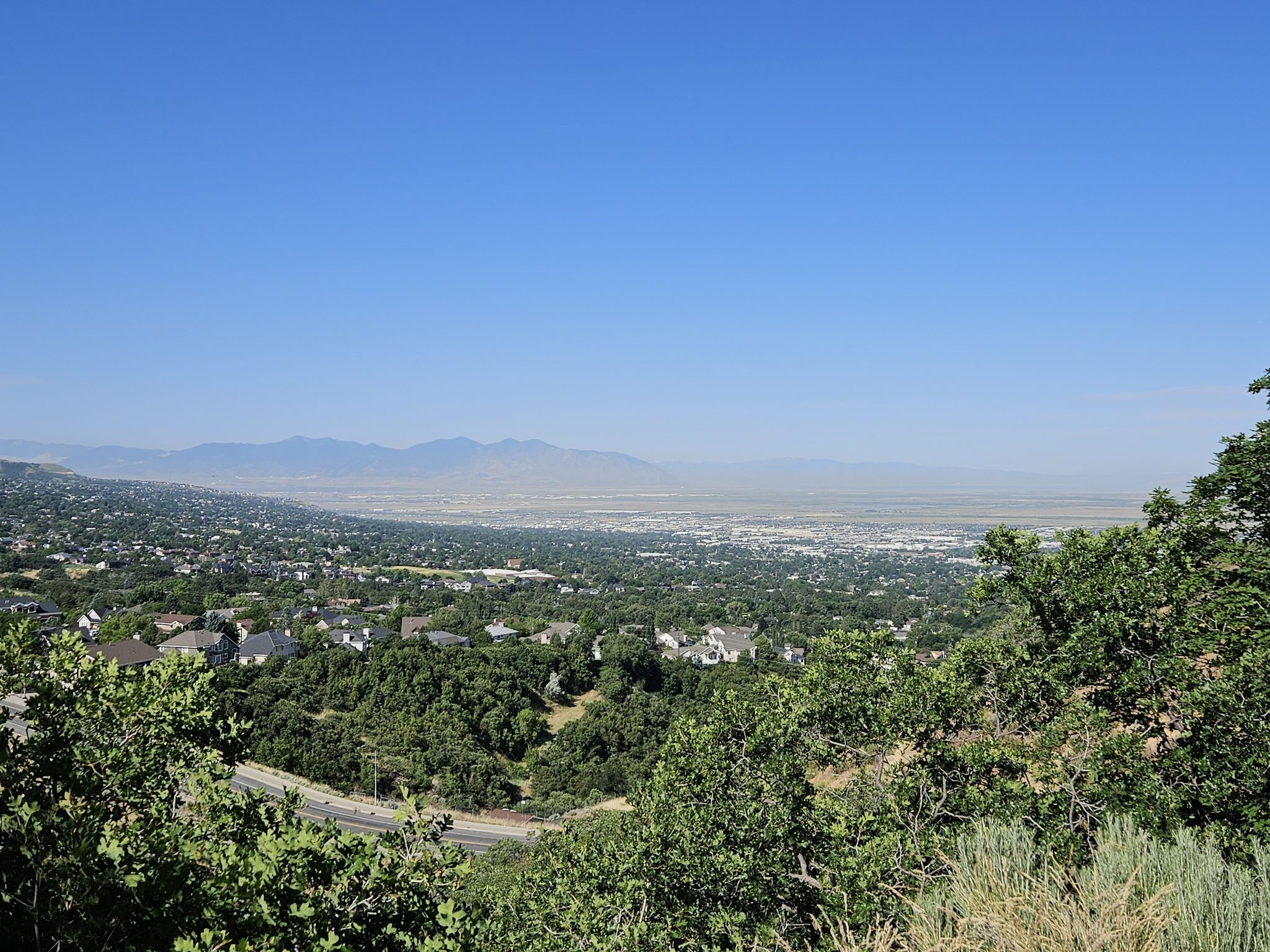 Panoramic view of a sprawling city and valley under a clear blue sky. - Temple Loop