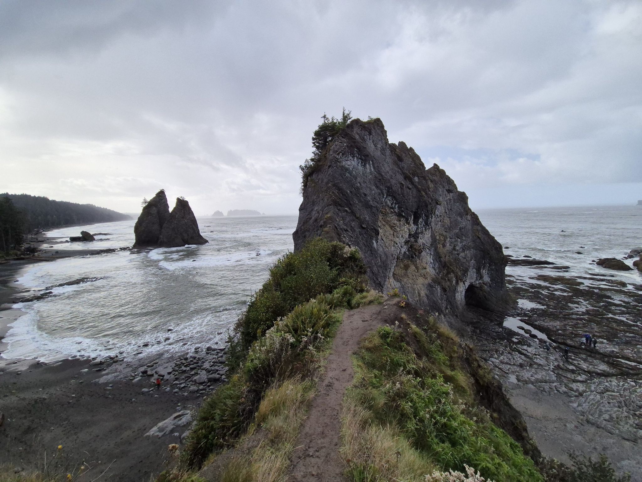 Path on a rocky ridge overlooking a turbulent ocean with sea stacks. - Hole in the Wall Trail