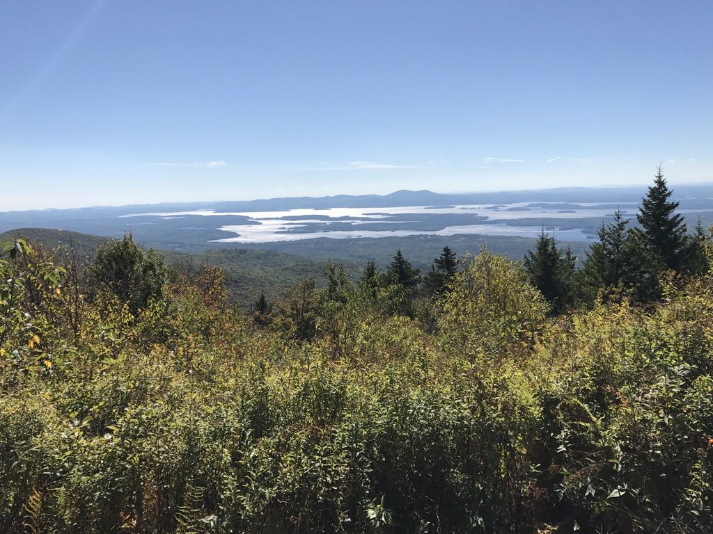 Panoramic view of a large lake and distant mountains under a clear sky. - Mount Roberts and Faraway Mountain Loop