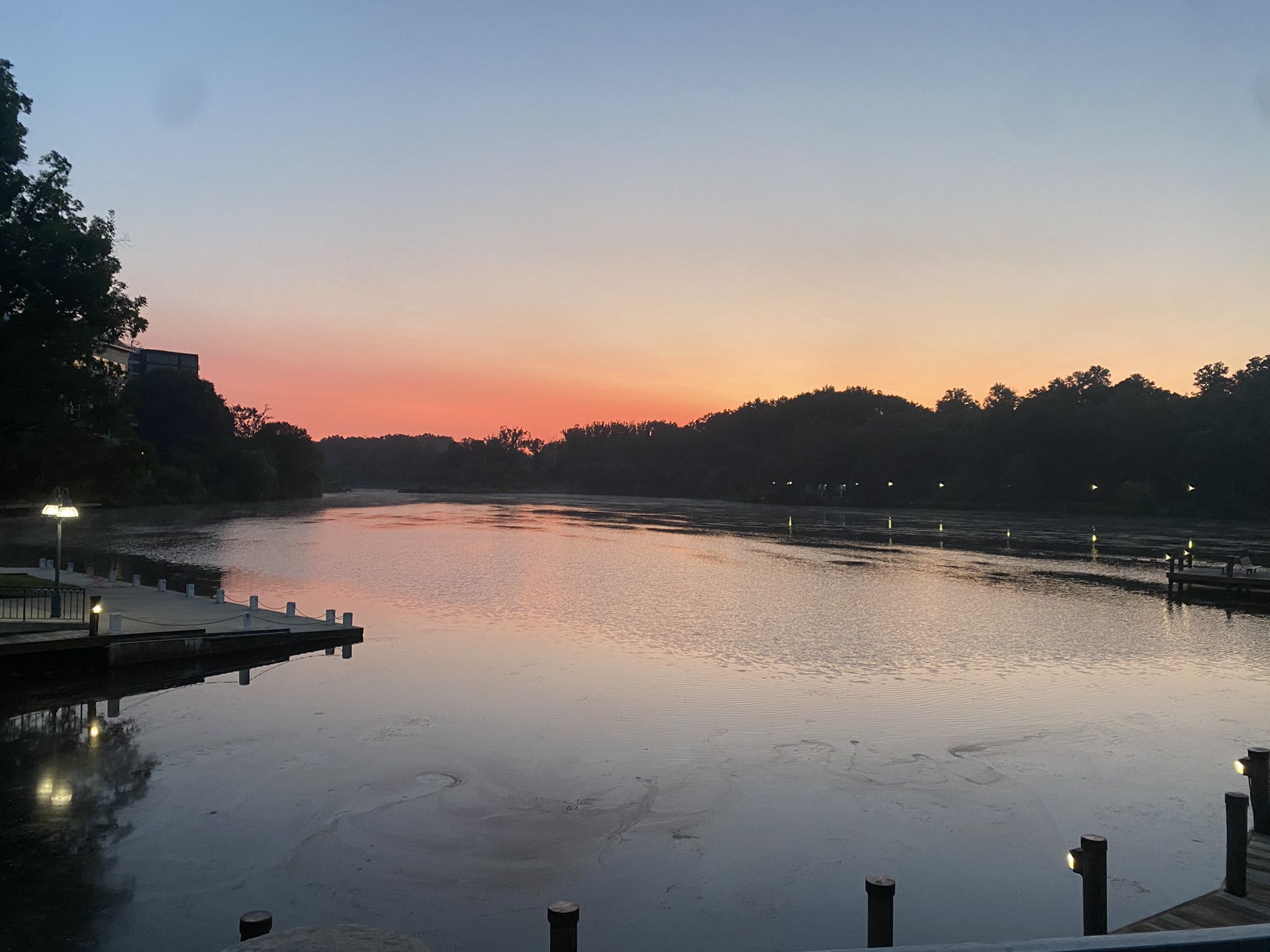 Wide lake at sunset with docks and illuminated lights along the dark shores. - Running loop from Merriweather Post Pavilion
