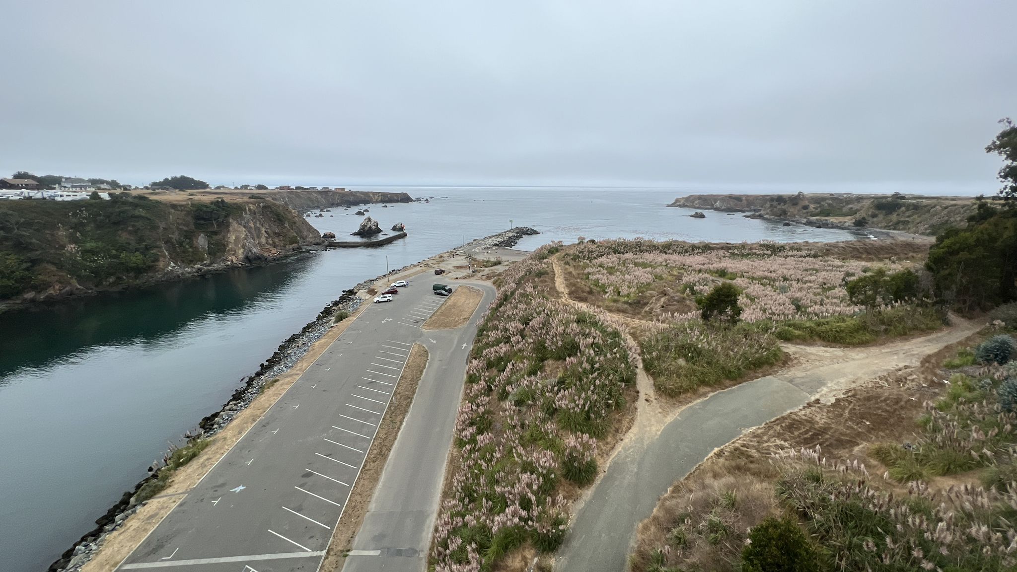 Overcast view of a river meeting the ocean, with a road and parking lot. - Ka Kahlen Trail — Haul Rd – Pudding Creek Beach loop from Henry's Meadow