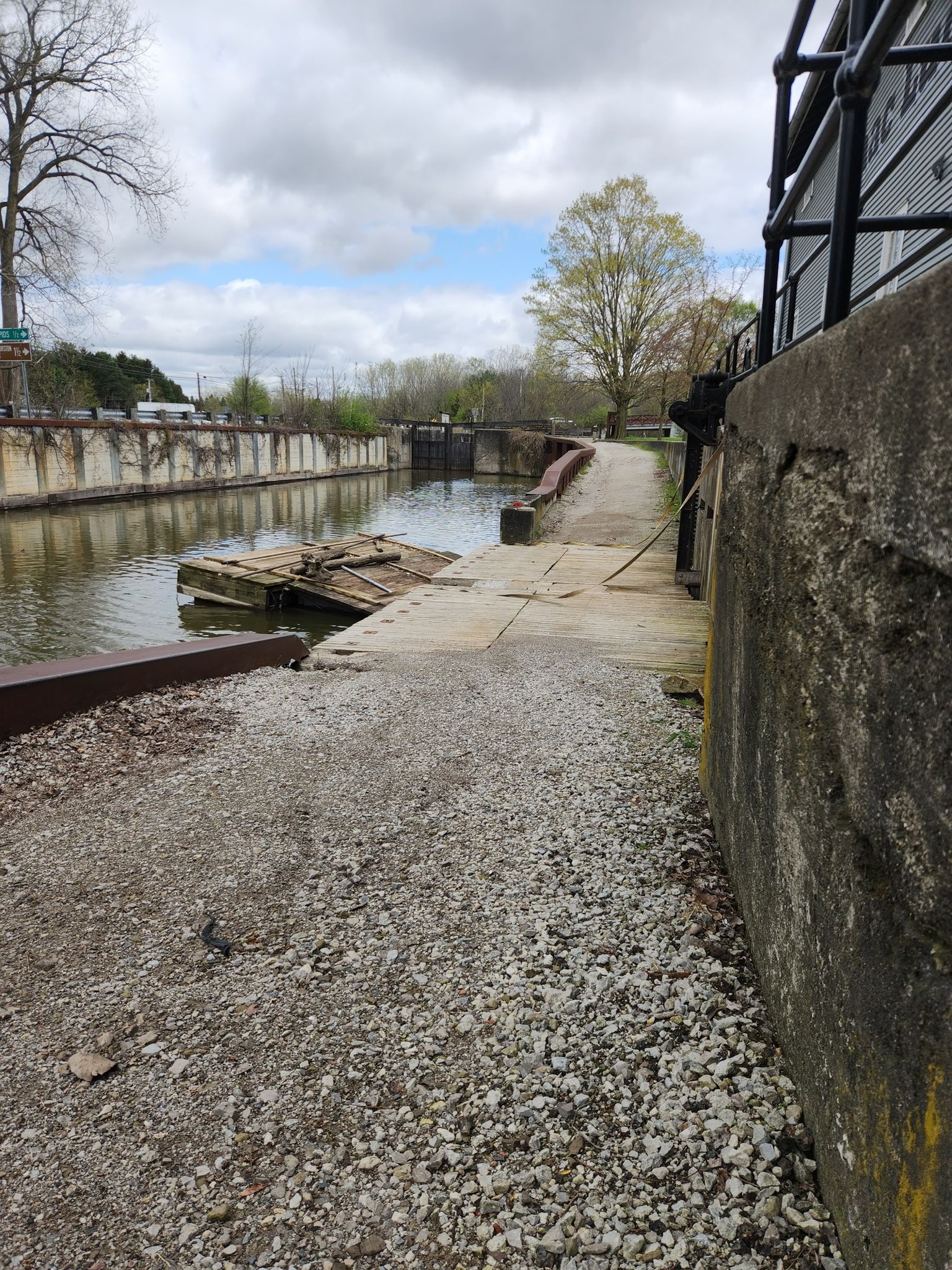 Overcast view of a canal lock with concrete walls and calm water. - Towpath Trail