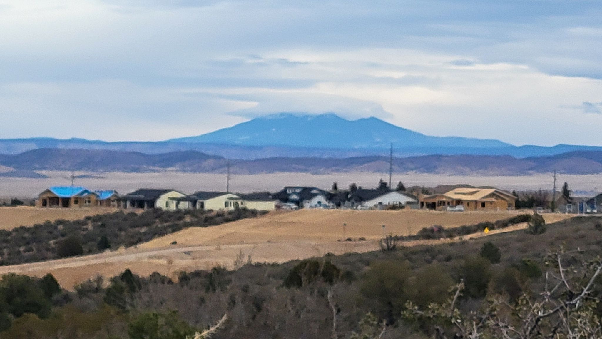 Residential houses on a hill overlooking a valley with a snow-capped mountain. - Longview and Legacy Trail Loop