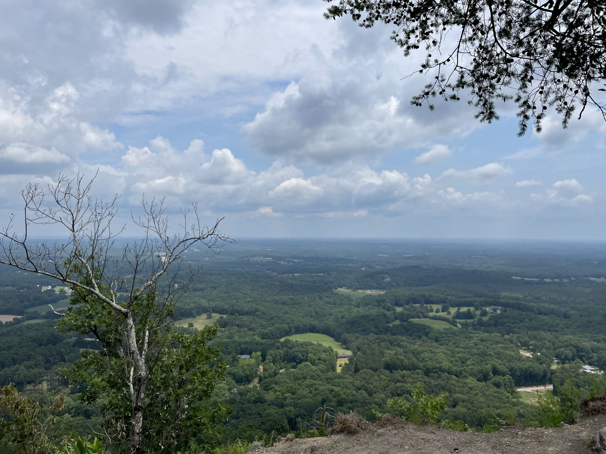 Expansive view of a green forested landscape under a cloudy sky. - Currahee Mountain Summit View – Lake Russell Road loop from Cornelia