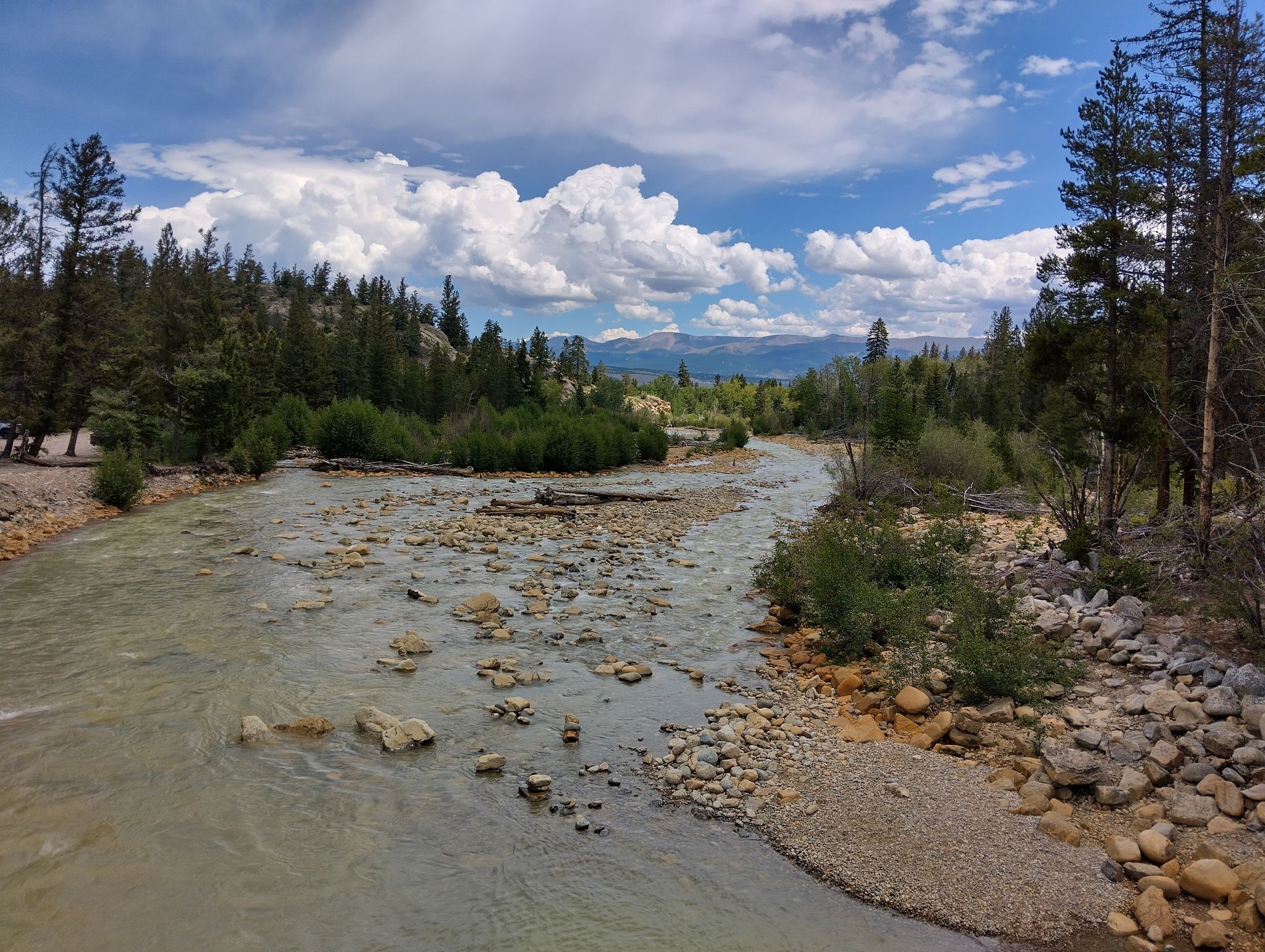 Wide river flowing through a forested valley under a cloudy sky. - Twin Lakes loop
