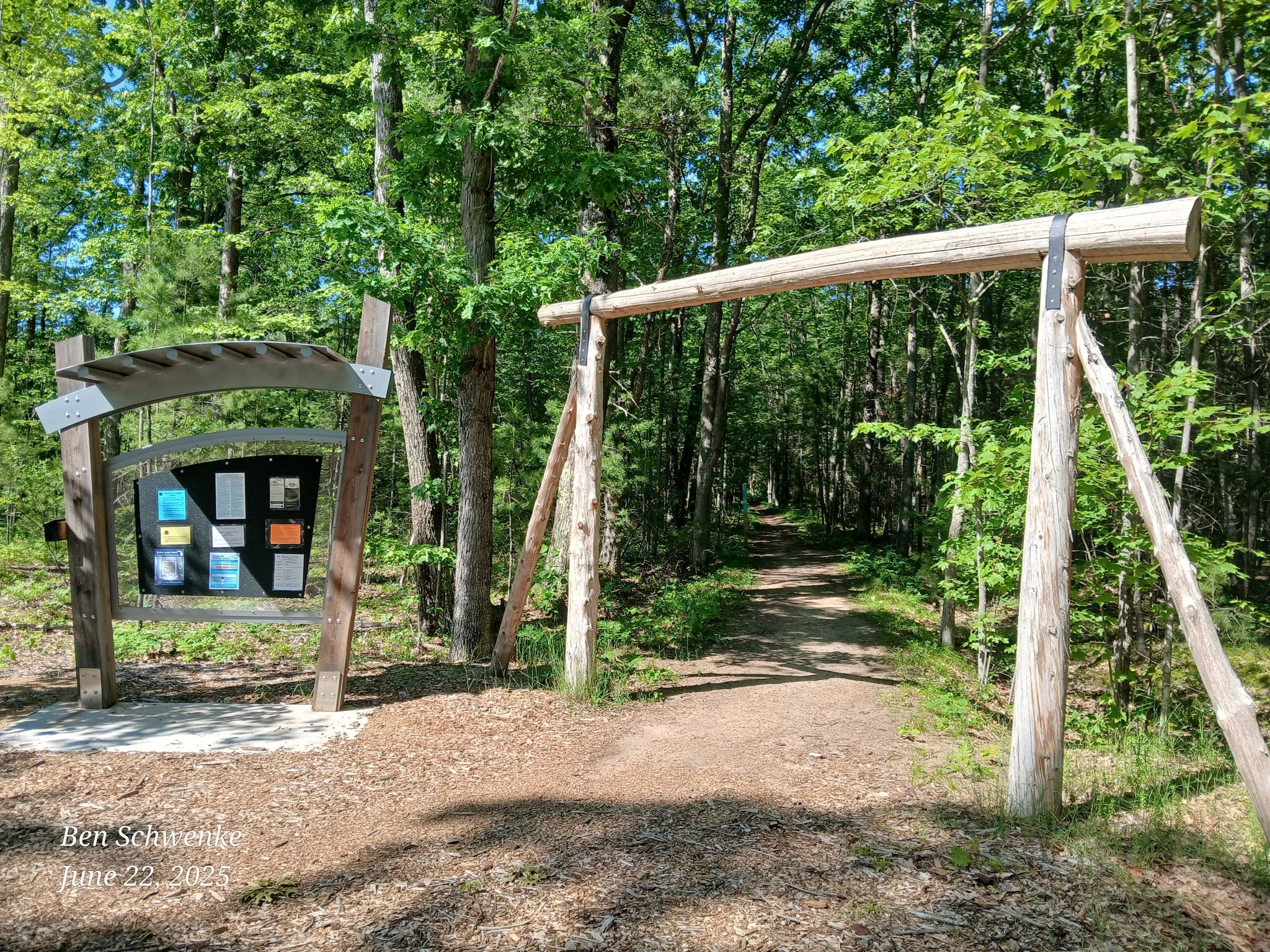 Wooden archway and information board at a sunny forest trail entrance. - Vasa Singletrack Loop