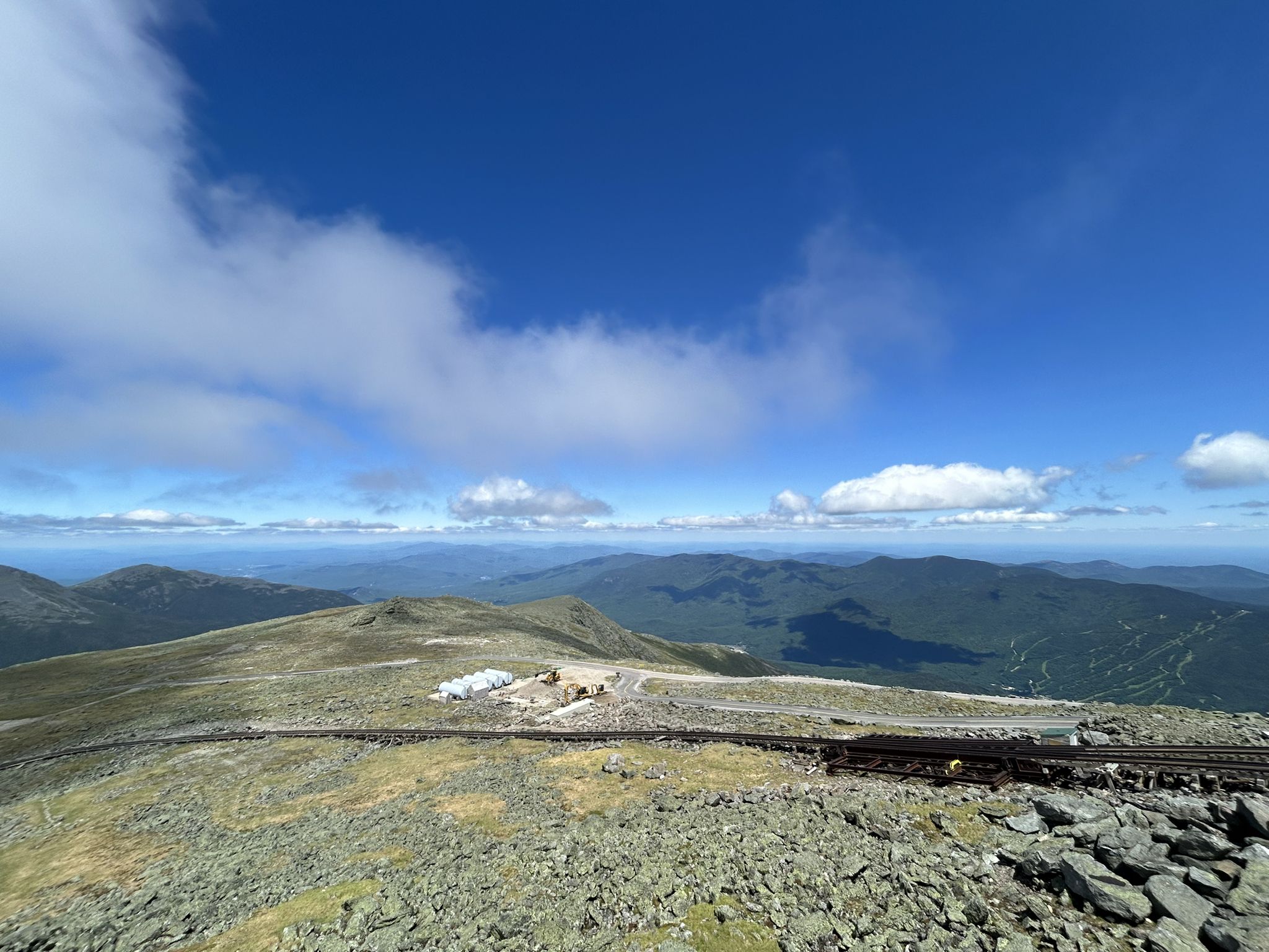 Panoramic view of rocky mountain summit with tracks and distant peaks. - Mount Washington via Huntington Ravine and Lion Head Trail