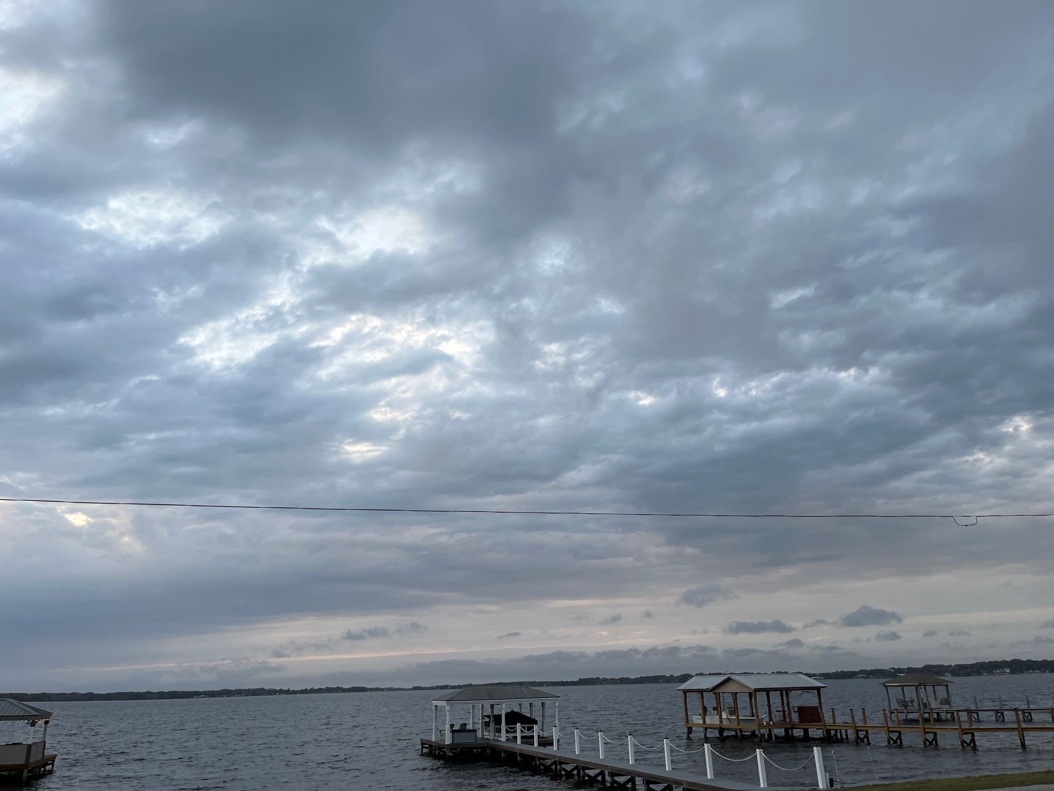 Overcast sky over a lake with several docks and covered boat slips. - South Lake Trail – West Orange Trail loop from Lake Louisa State Park