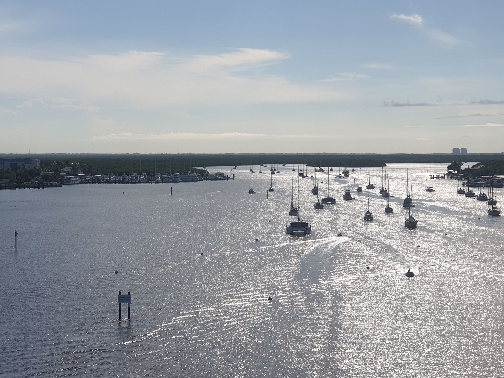Aerial view of many boats anchored in a sunny, sparkling wide waterway. - Times Square, Fort Myers Beach – View of Estero Boulevard loop from Smugglers Cove - adventure golf