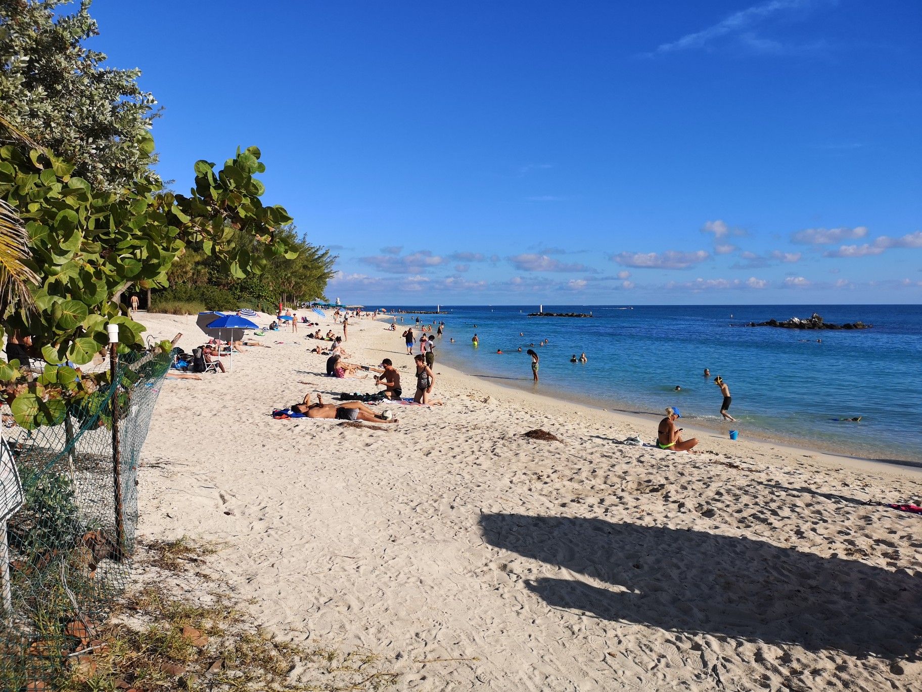 Sunny beach with many people relaxing and swimming in blue ocean. - St. Pauls Episcopal Church – Fort Zachary Taylor State Park loop from Key West
