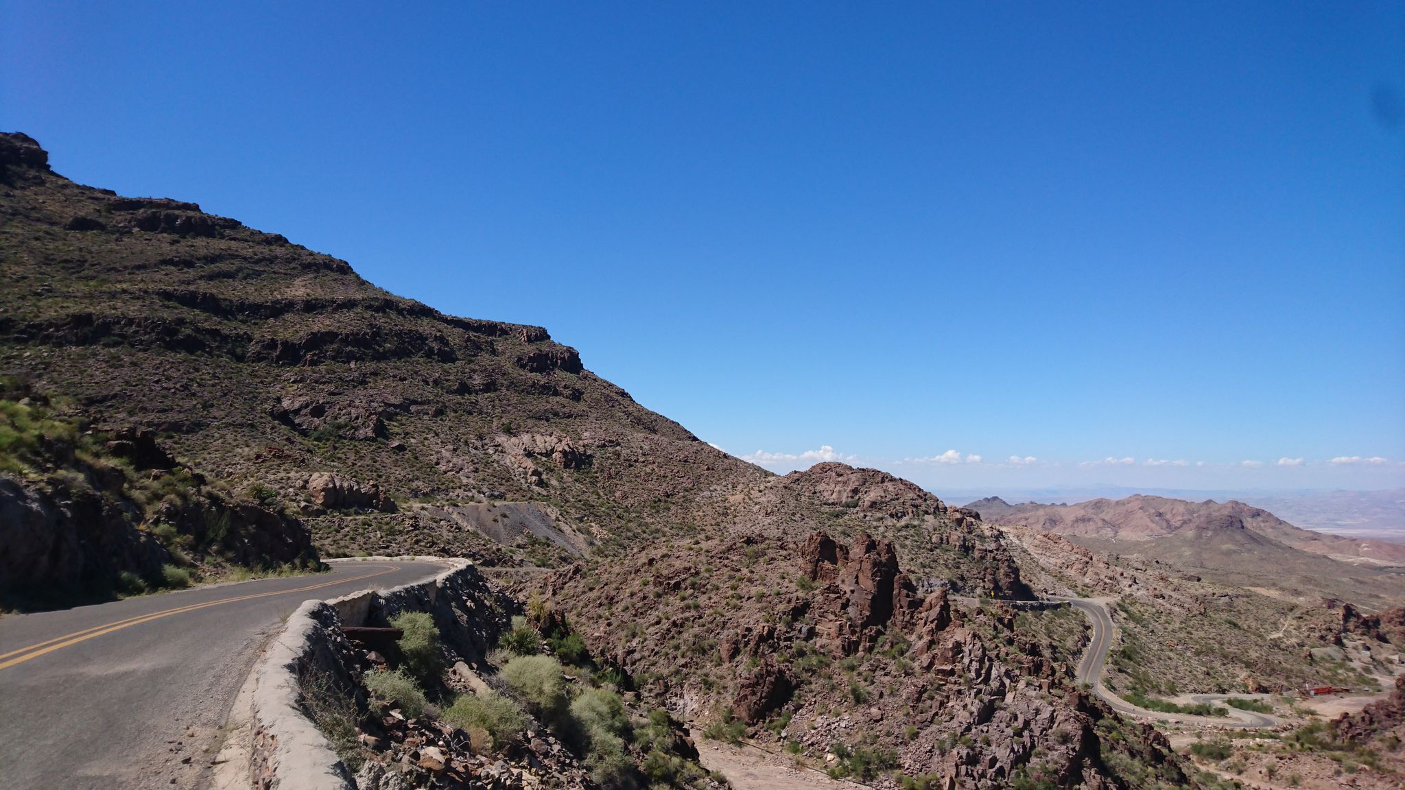 Winding road along a steep, rocky desert mountain under clear sky. - Oatman to Sitgreaves Pass via Historic Route 66