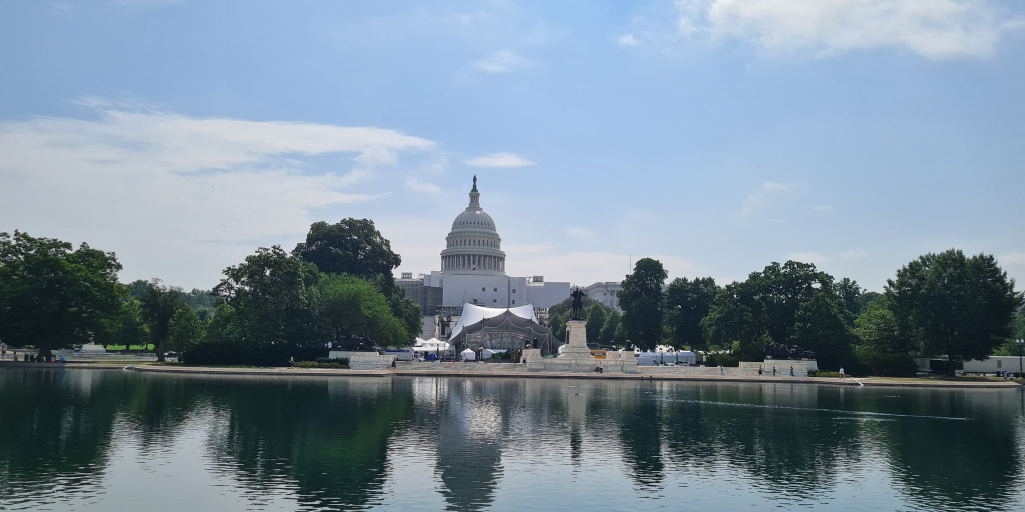 Domed building reflecting in water, green trees, bright blue sky. - U.S. Capitol – Capitol Reflecting Pool loop from Eastern Market