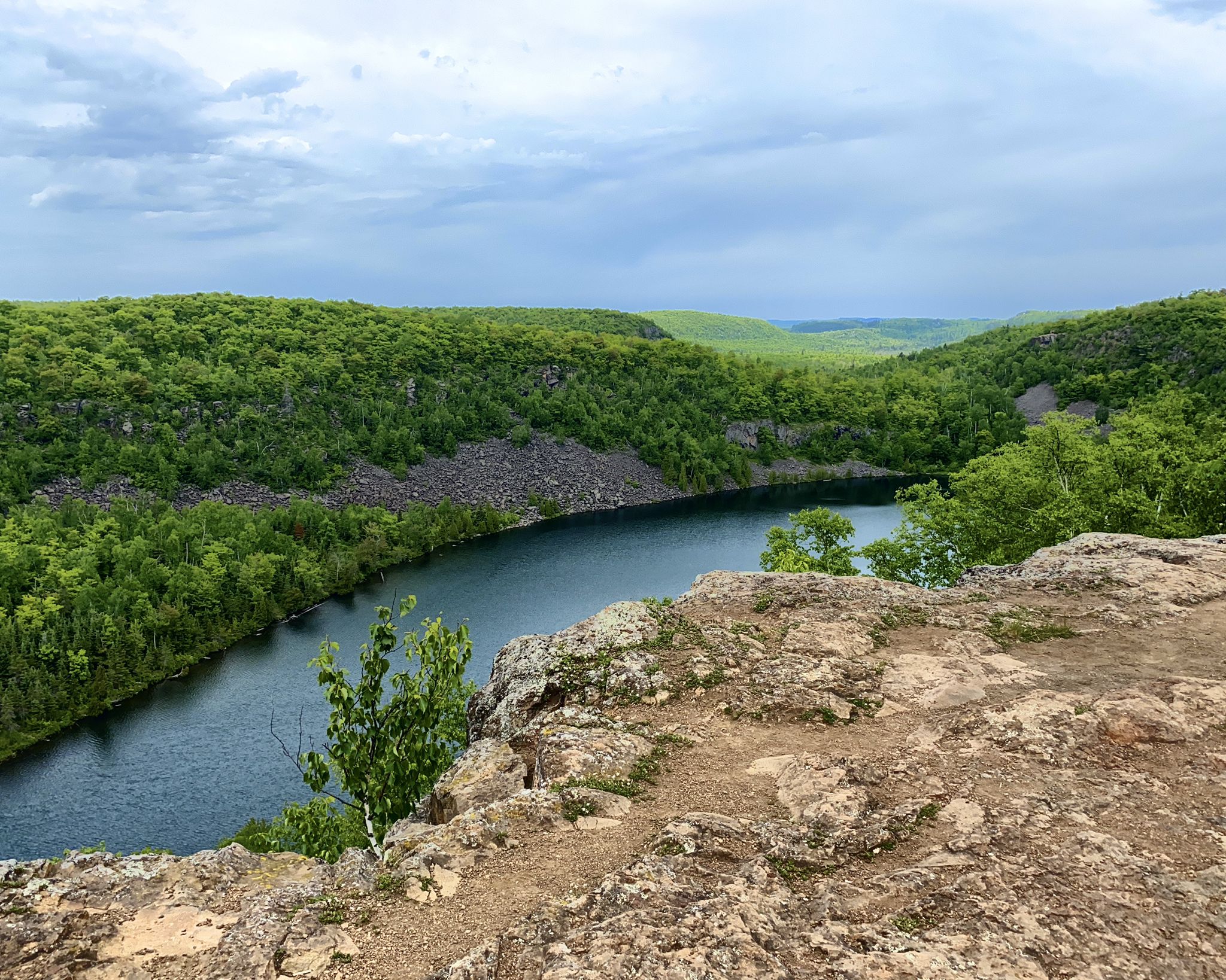 Lake winding through green forested hills from a rocky viewpoint under cloudy sky. - Bean Lake & Bear Lake loop via Superior Hiking Trail