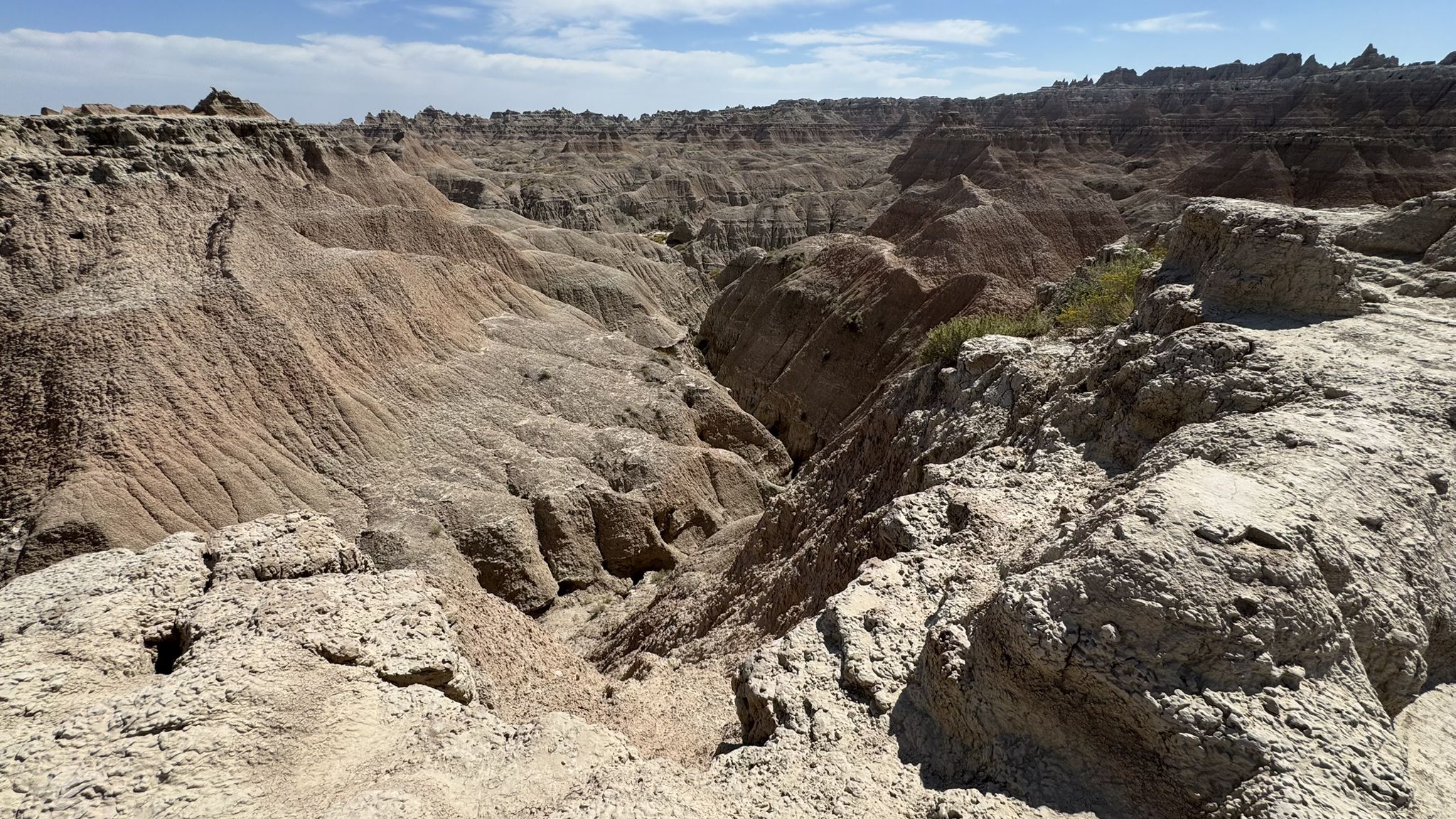 Deep, eroded canyon with rugged rock formations under a partly cloudy sky. - Door Trail