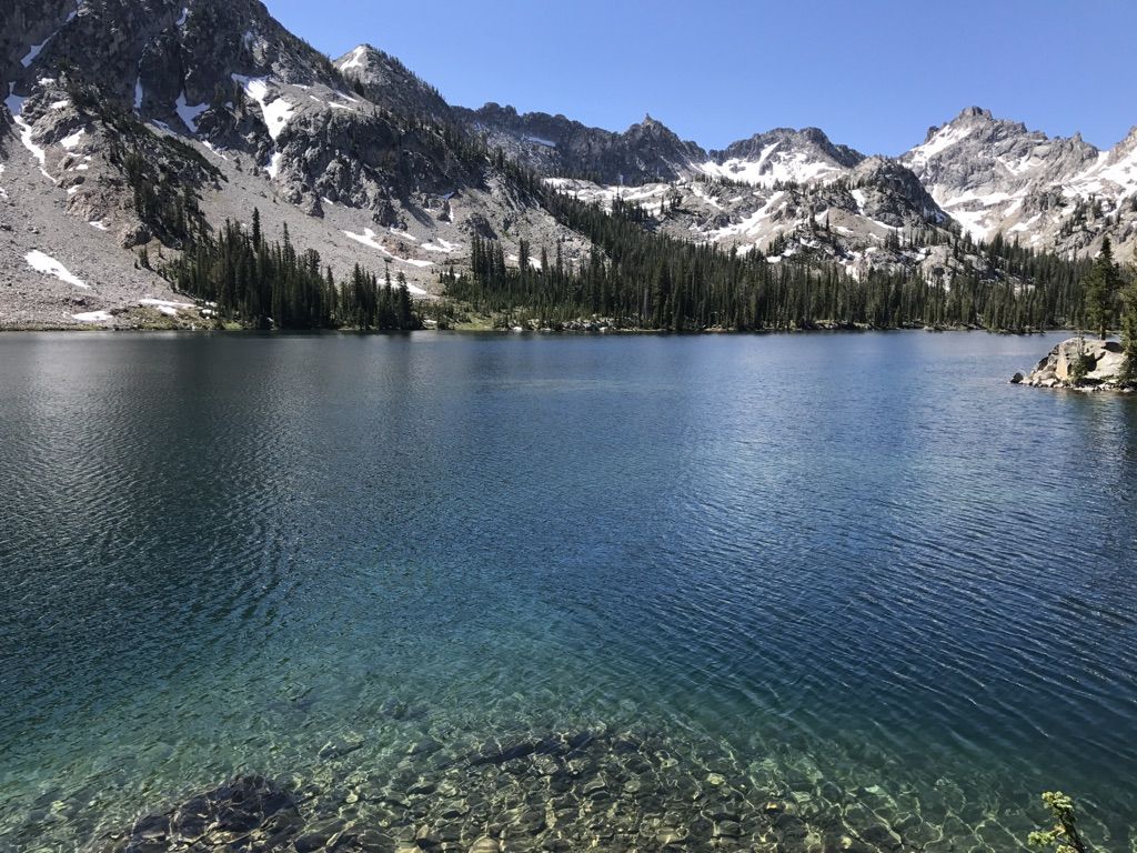 Clear mountain lake with snow-capped peaks and pine forests under bright sun. - Alice Toxaway Loop (Tin Cup Hiker Loop) — Tin Cup Hiker Trailhead