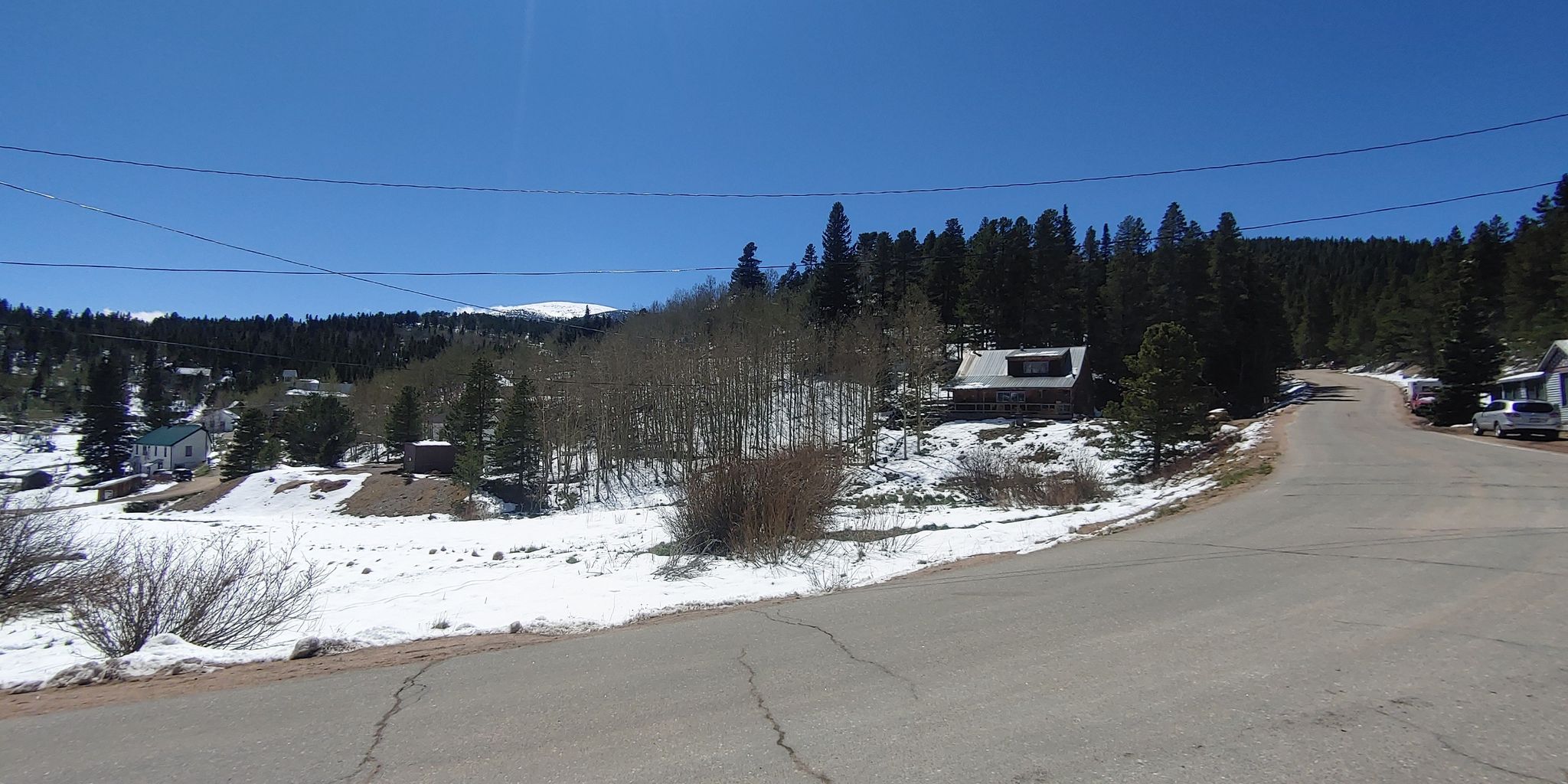 Snowy mountain village with cabins and pine trees under a clear blue sky. - Ward General Store – Mud Lake loop from Minnie Lake