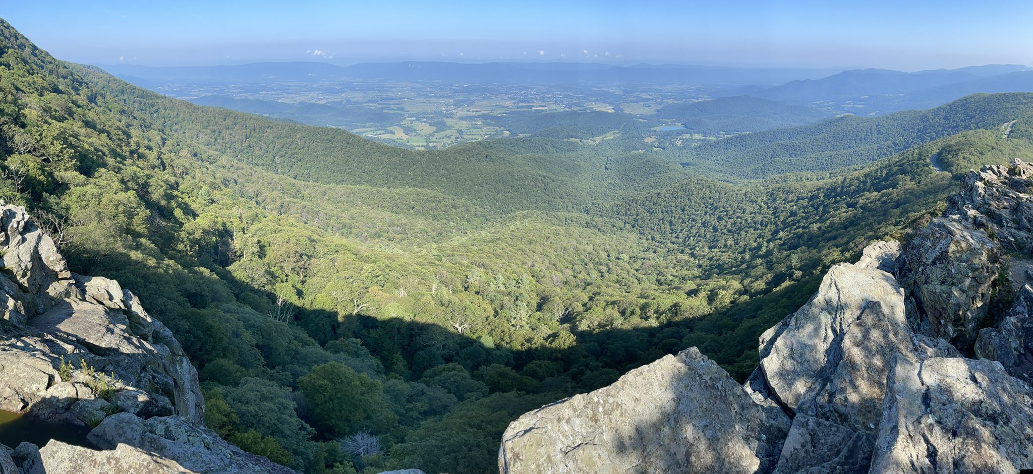 Panoramic view of a vast green mountain valley under a clear sky. - Passamaquoddy Trail