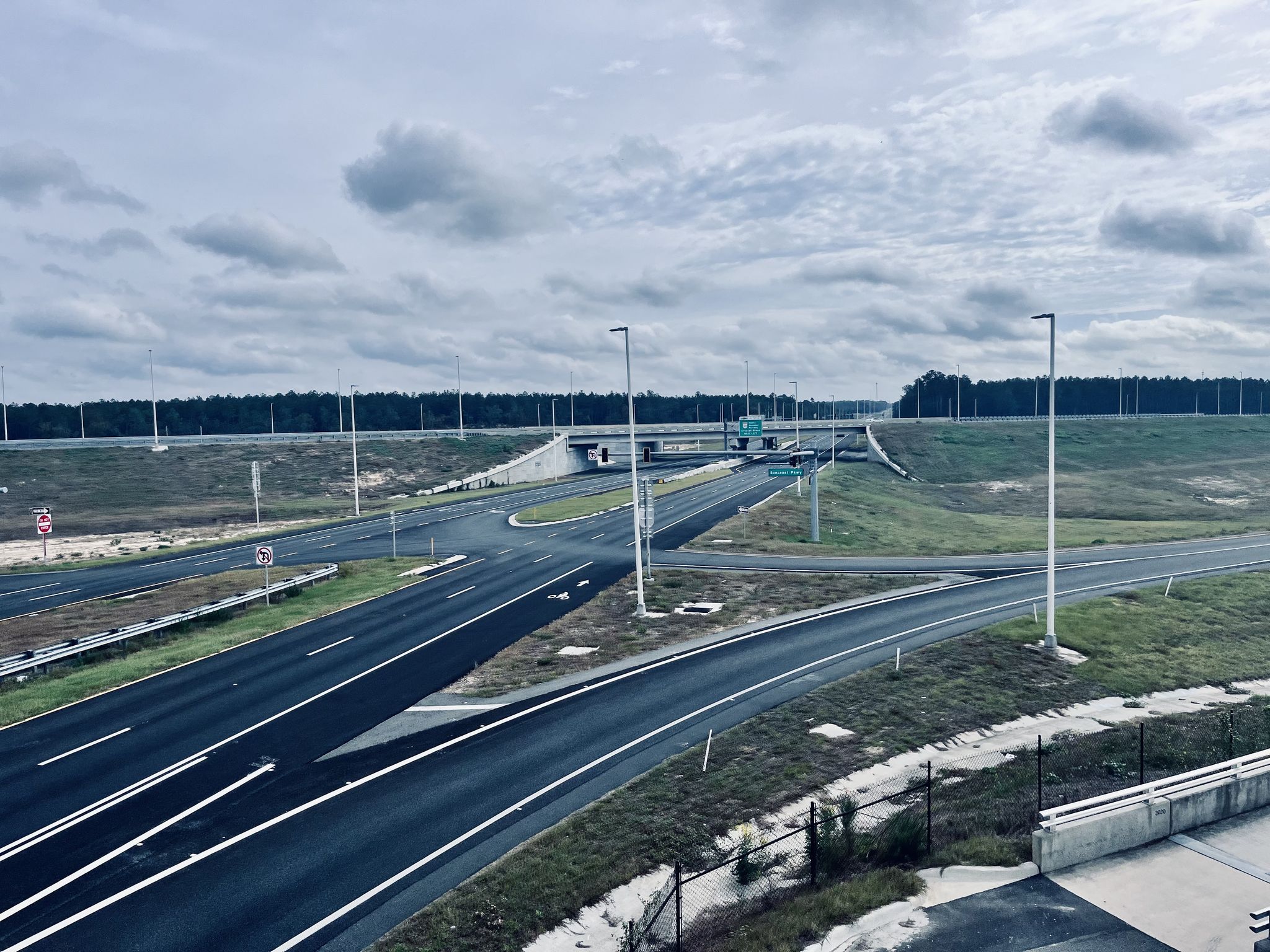 Overcast view of a multi-lane highway interchange with grassy embankments. - Restrooms and water fountain – Suncoast Trail loop from Spring Hill